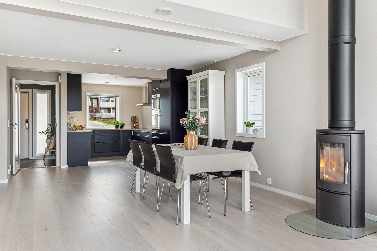 Mellom sofa og spisebord har stuen en peisovn med stort glassfelt som gjør det ekstra varmt og koselig på kjølige dager. Galleribilde