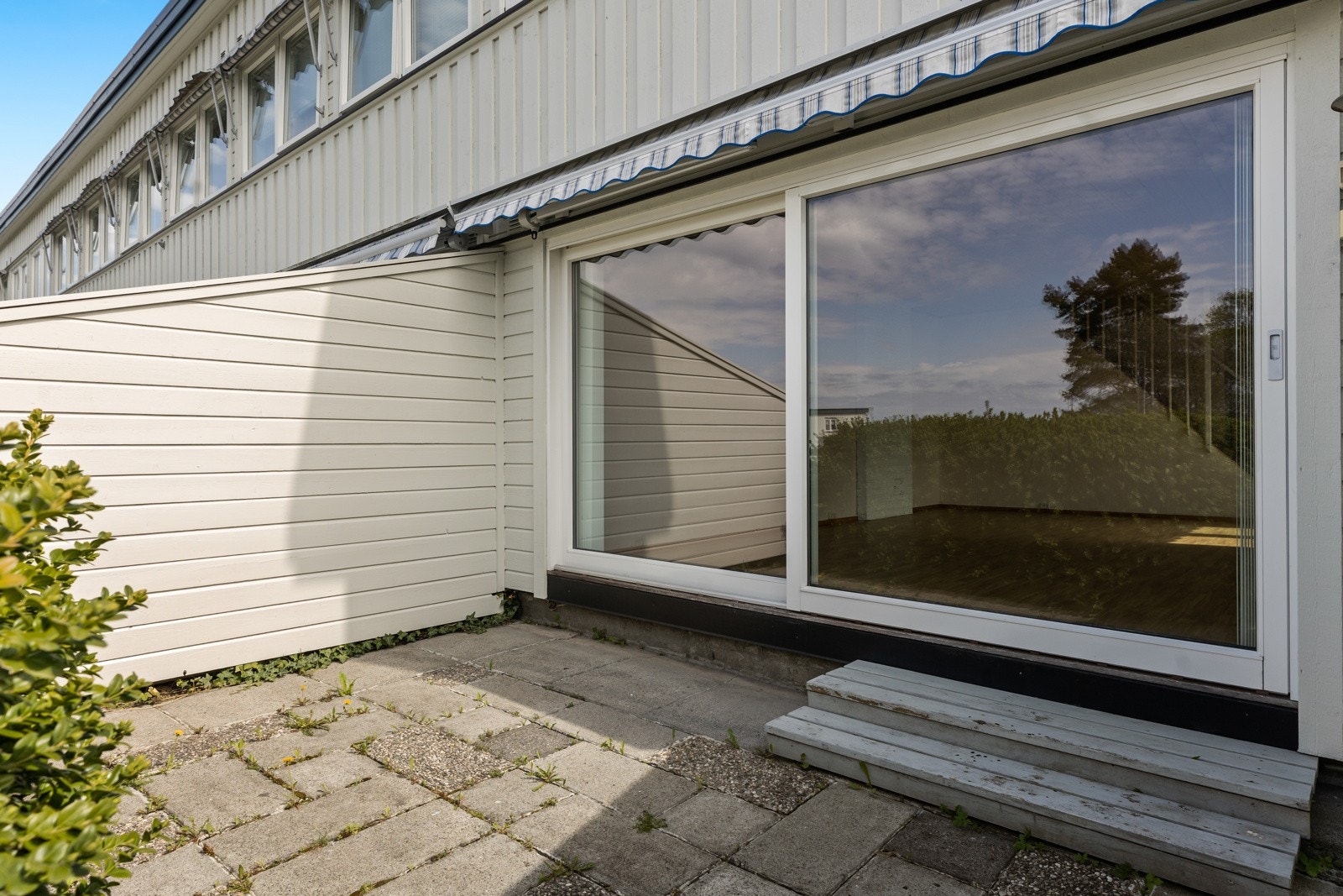 Via stor skyvedør har du utgang til markterrassen. I sommerhalvåret, når døren står oppe, går ute og inne i ett. Galleribilde