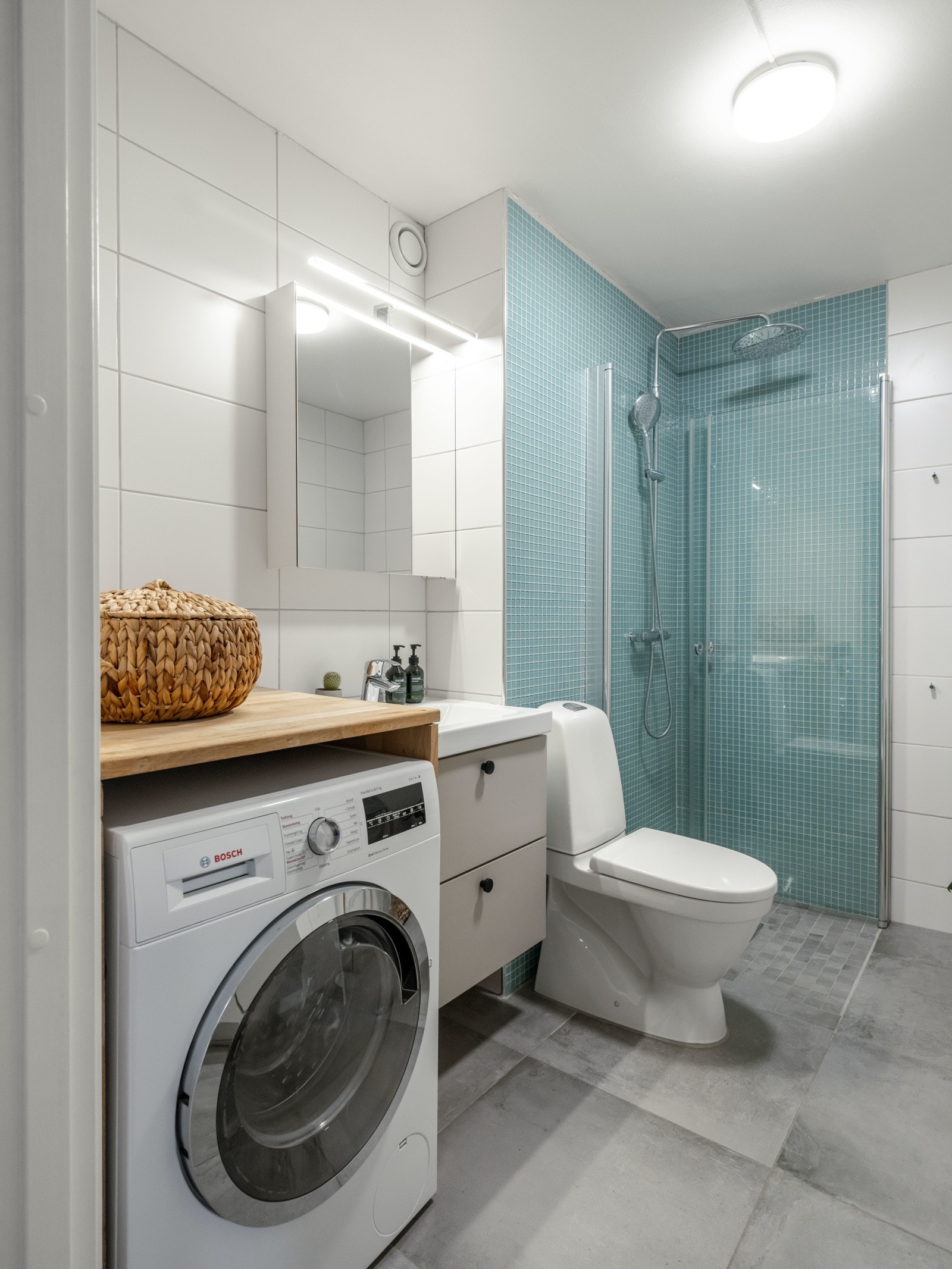 Badet er innredet med dusjhjørne, servant med innredning, vaskemaskin og toalett. Galleribilde