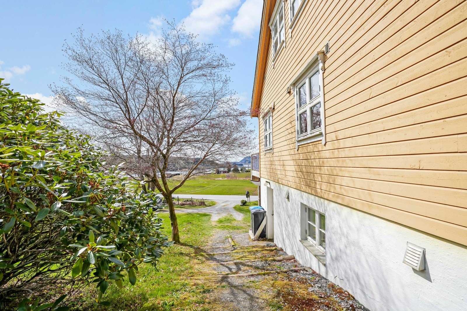 Tomta rundt boligen er fint opparbeida med skiferbelagte gangareal, platninger, hage med plen og div. beplatning Galleribilde
