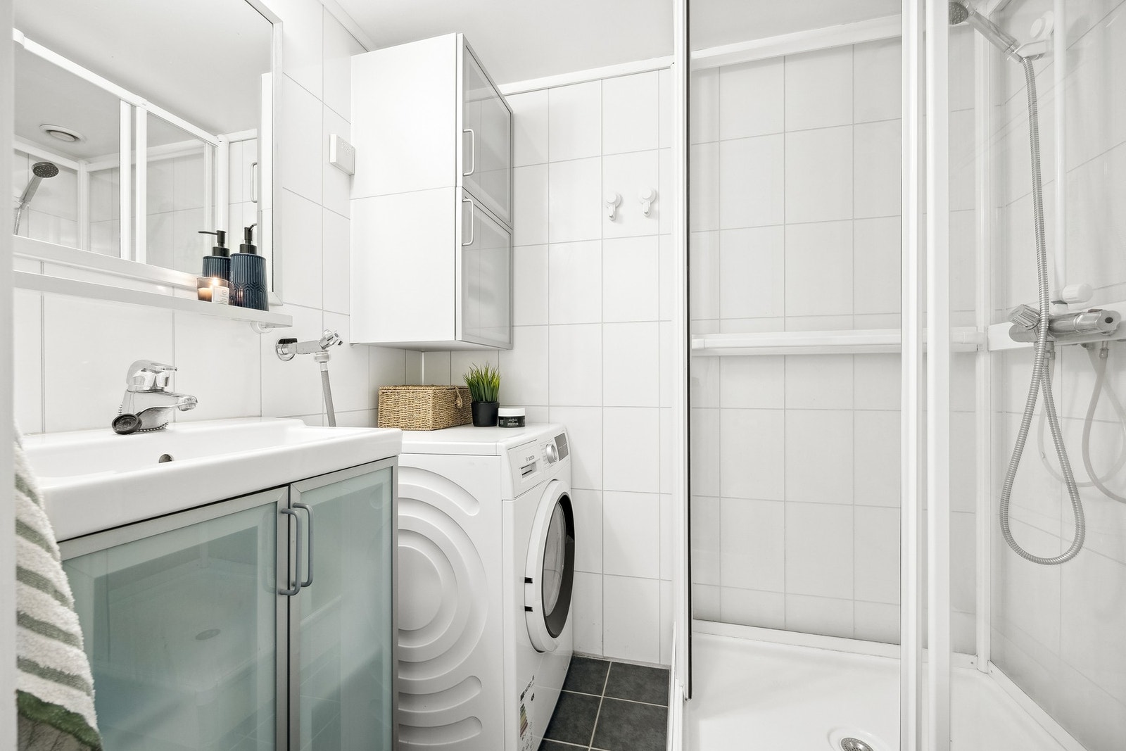 Badet har plass til alt man trenger. Membranskånsomt dusjkabinett, kran og avløp for vaskemaskin og gulvstående wc. Galleribilde