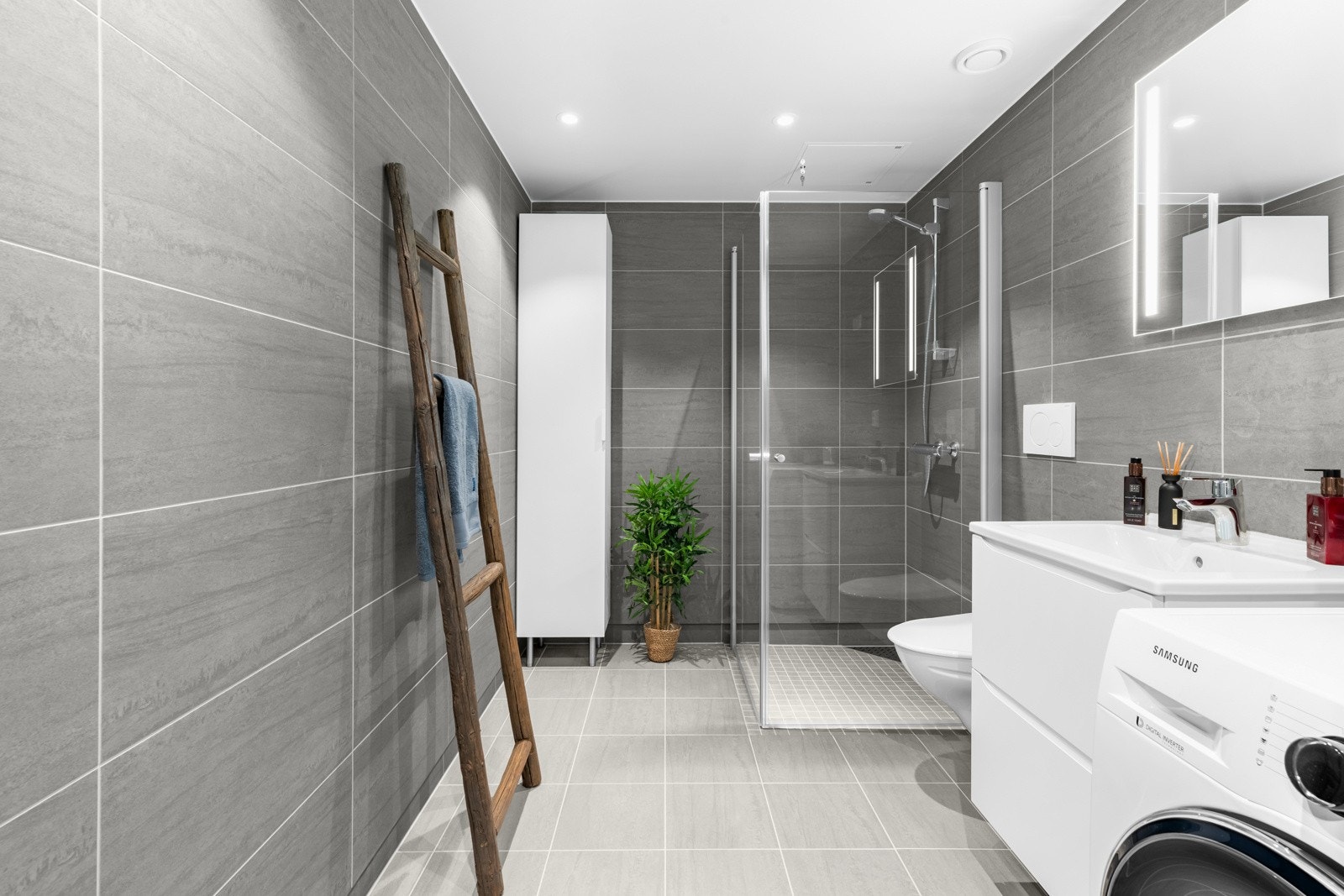 Lekkert, flislagt baderom som er både tidløst, praktisk og romslig. Galleribilde