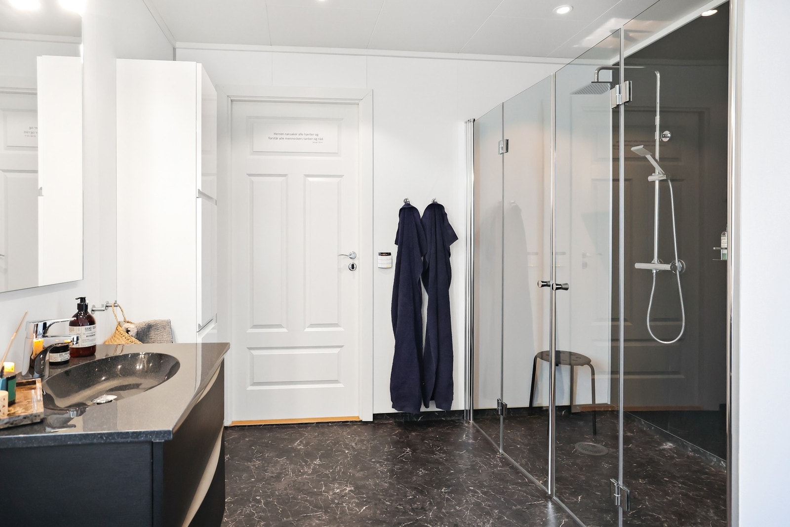 I tillegg inneholder rommet blant annet servantinnredning med skuffer, ovenpåliggende servant med armatur, speil med overlys og stikkontakt over servant, baderomsmøbel og toalett. Galleribilde