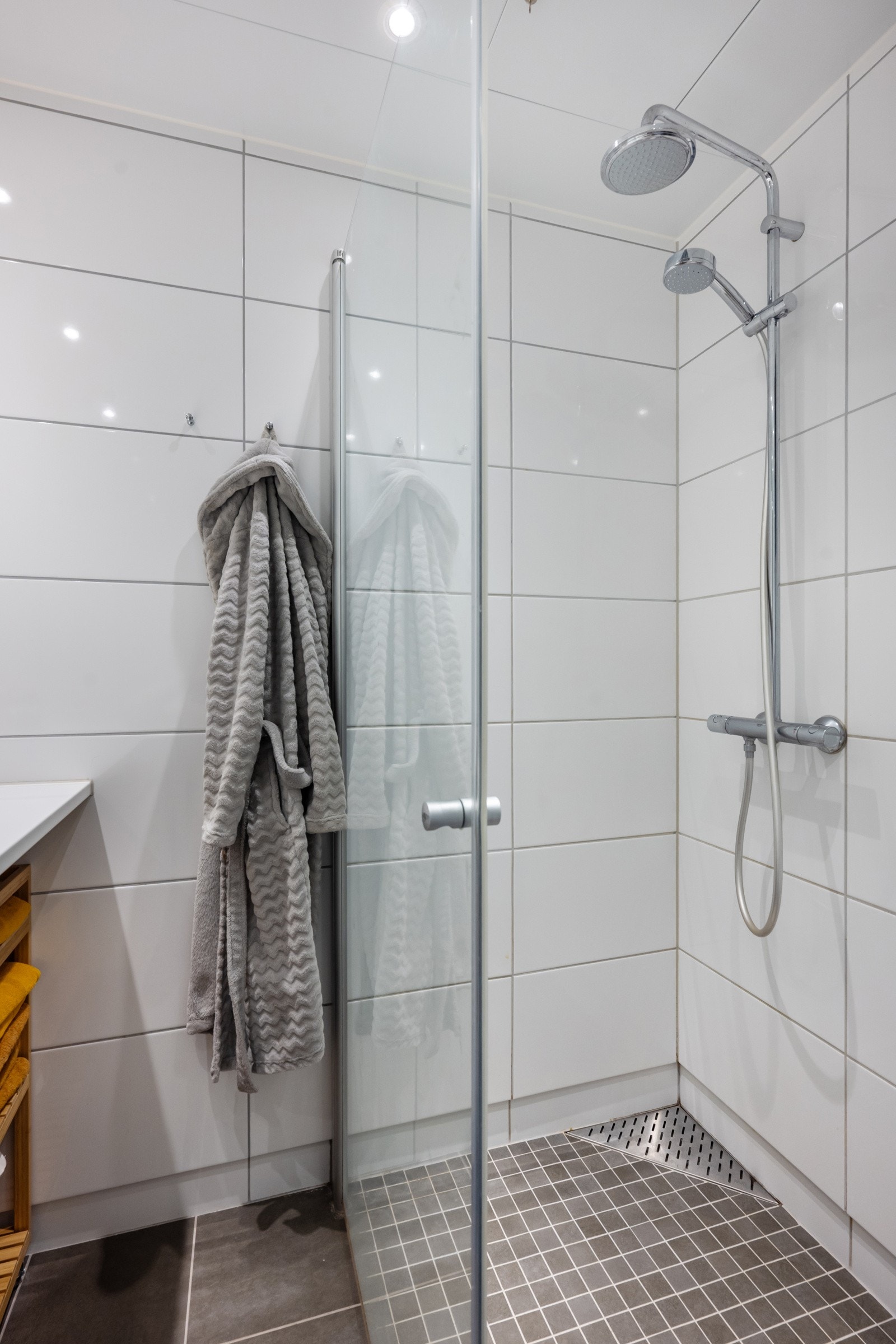 Dusjhjørnet har innfellbare glassdører og regnfallsdusj. Galleribilde