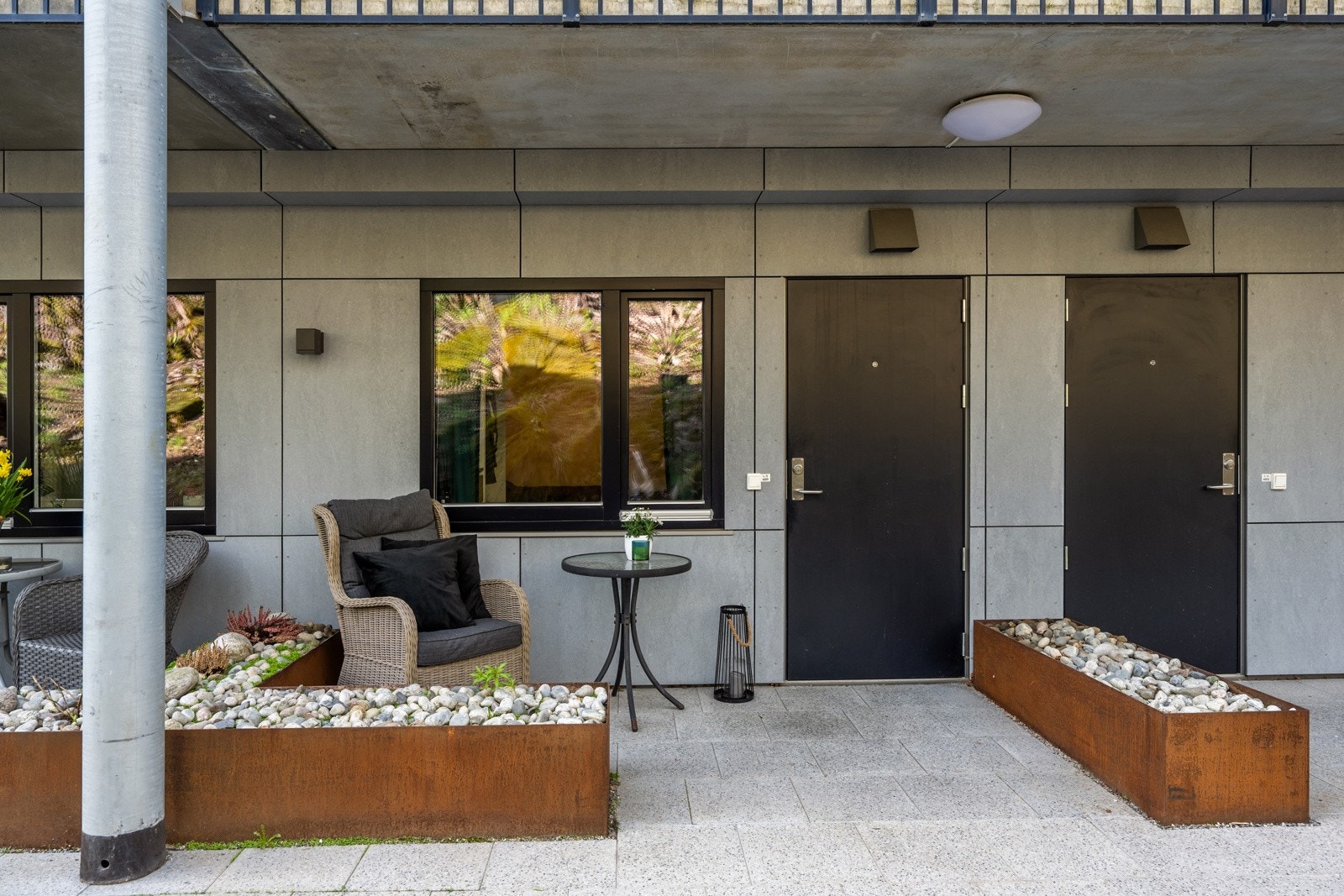 Uteplassen ved inngangspartiet har moderne blomsterbed mot naboene og plass til utemøbler. Galleribilde