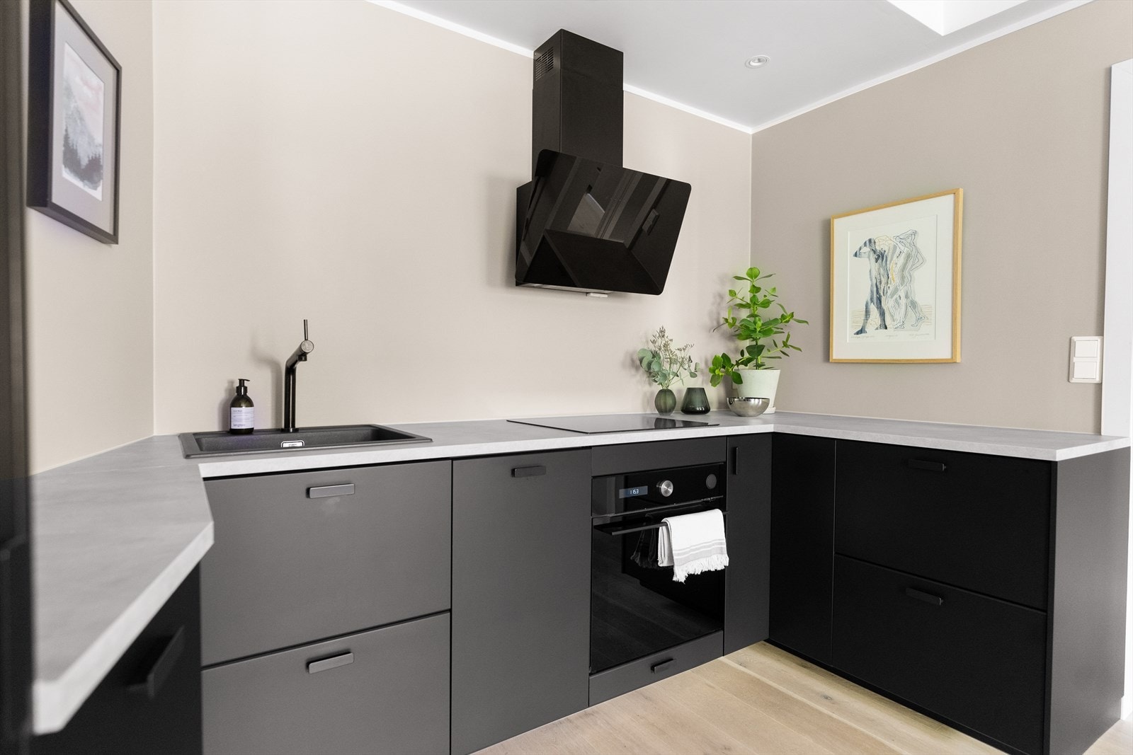 Integrerte hvitevarer som stekeovn, induksjonstopp, oppvaskmaskin og kjøleskap med frysedel. Galleribilde