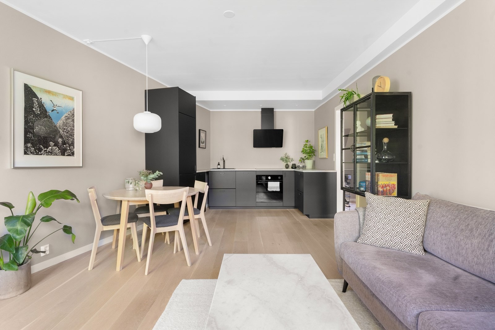 Et sosialt oppholdsrom med god plass til sofa, spisebord og tilhørende møblement. Galleribilde