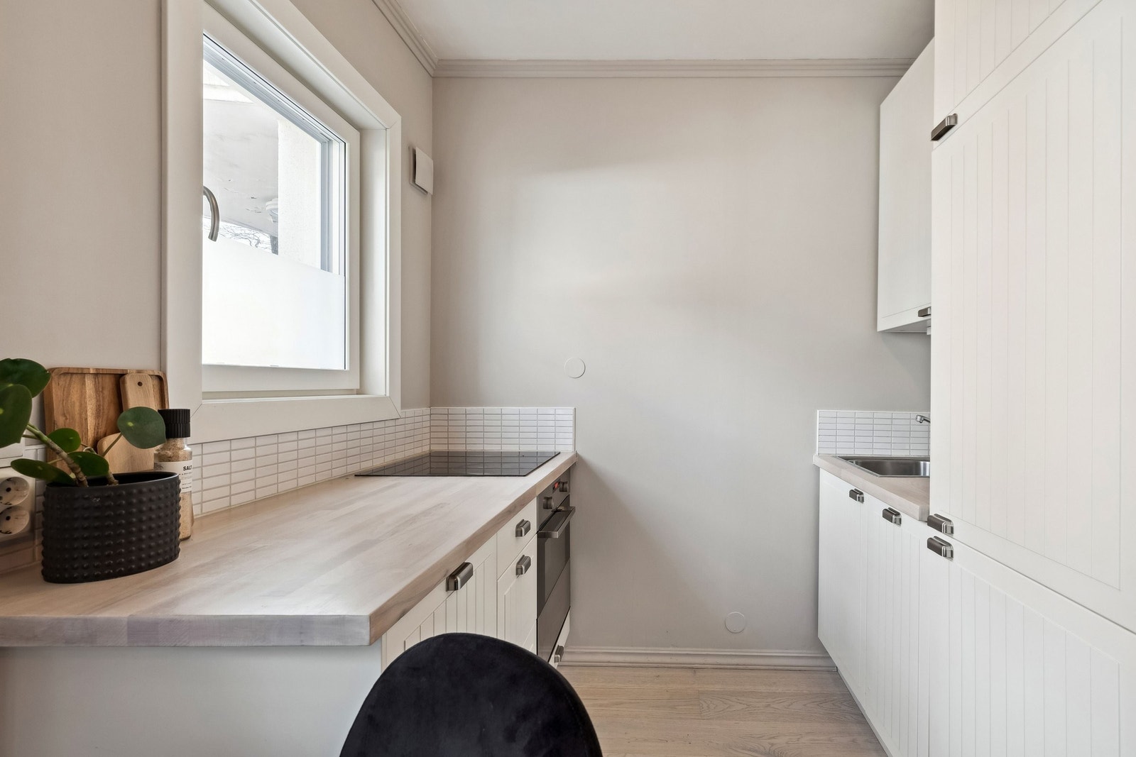 Moderne kjøkken med god skap- og benkeplass. Fronter med riller og benkeplate i heltre. Galleribilde