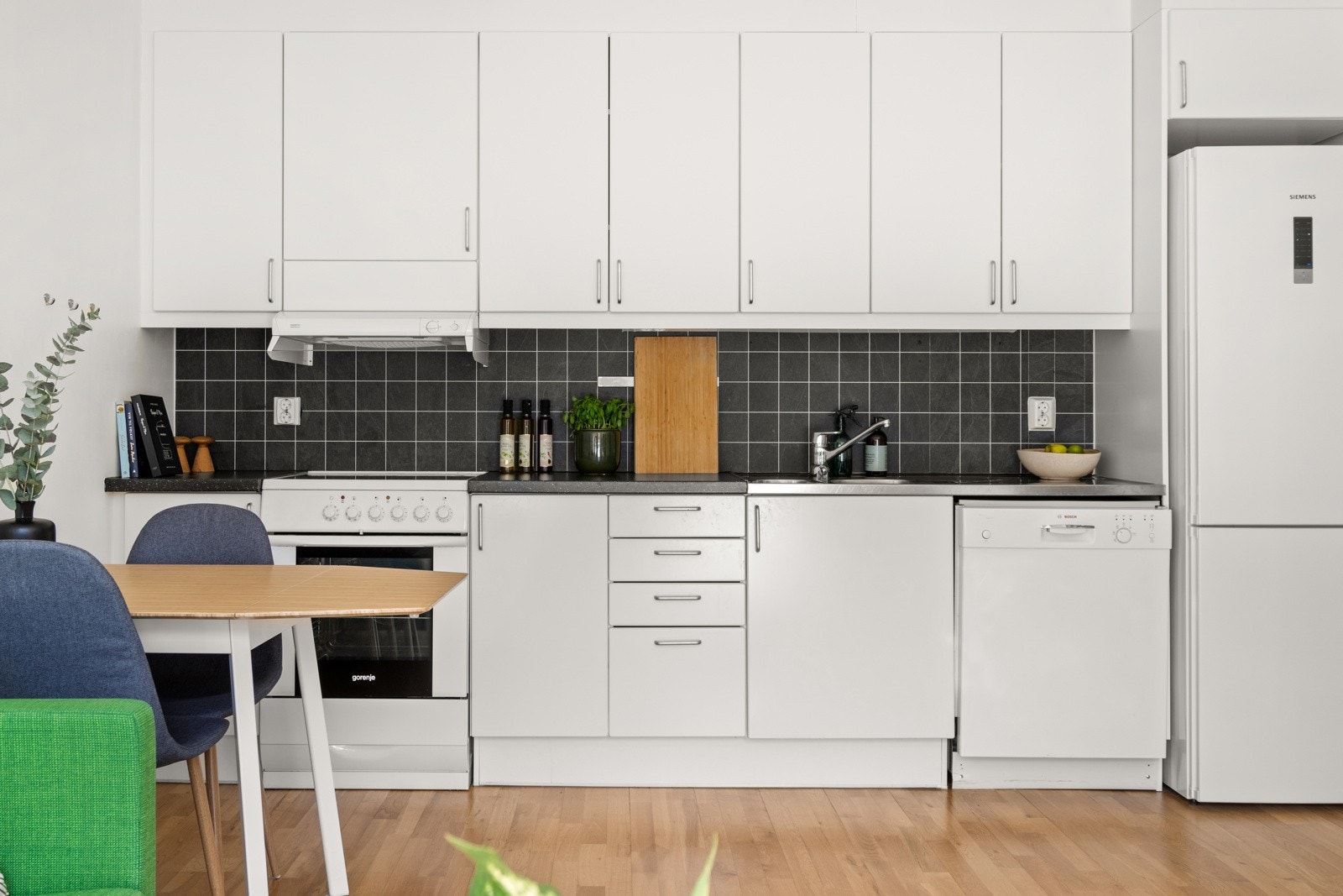 Kjøkkeninnredning med glatte fronter og laminat benkeplater. Galleribilde