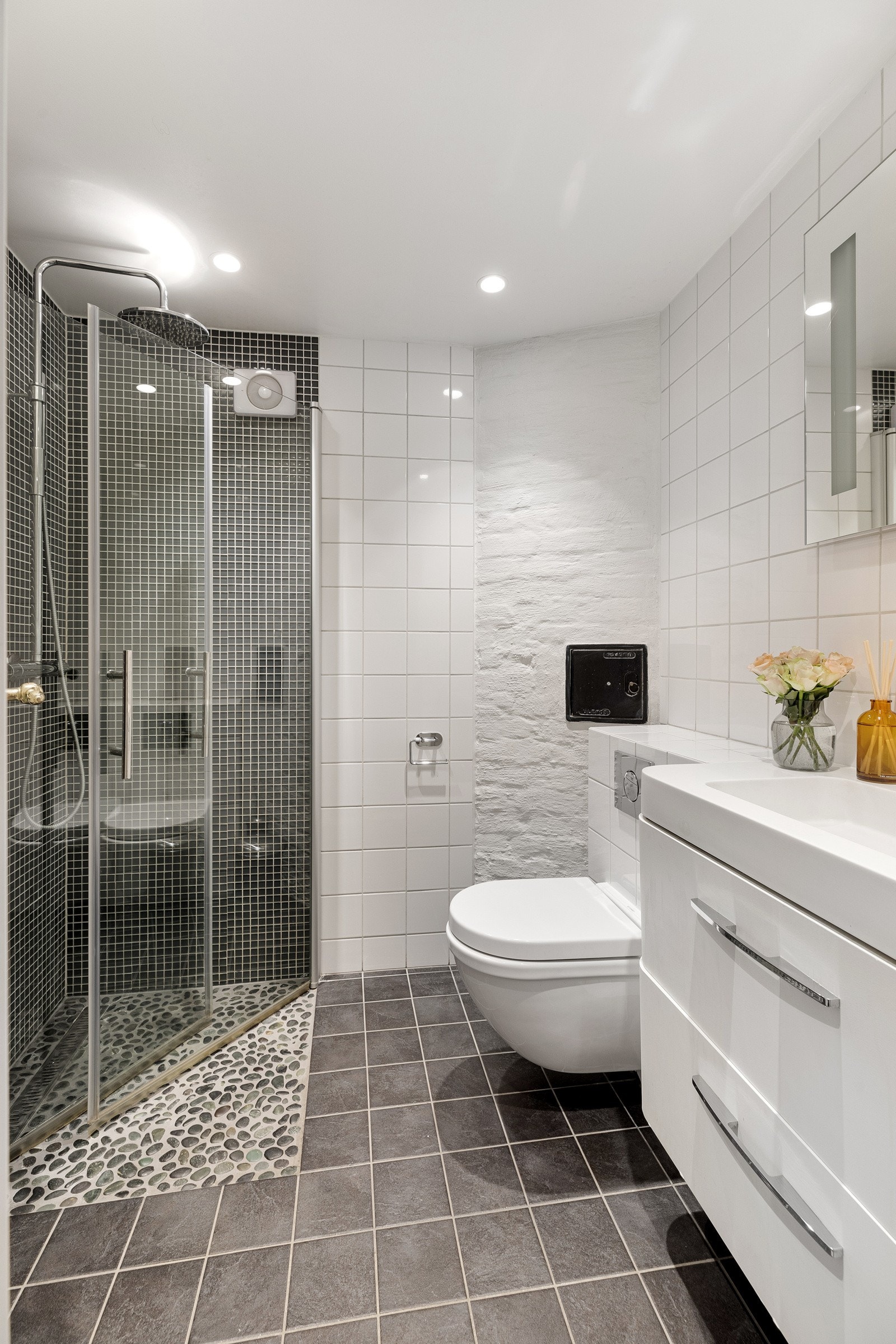 Attraktivt baderom fra 2012. Utstyrt med varmekabler, servant, vegghengt toalett og dusjhjørne. Det er montert en elektrisk avtrekksvifte. Galleribilde