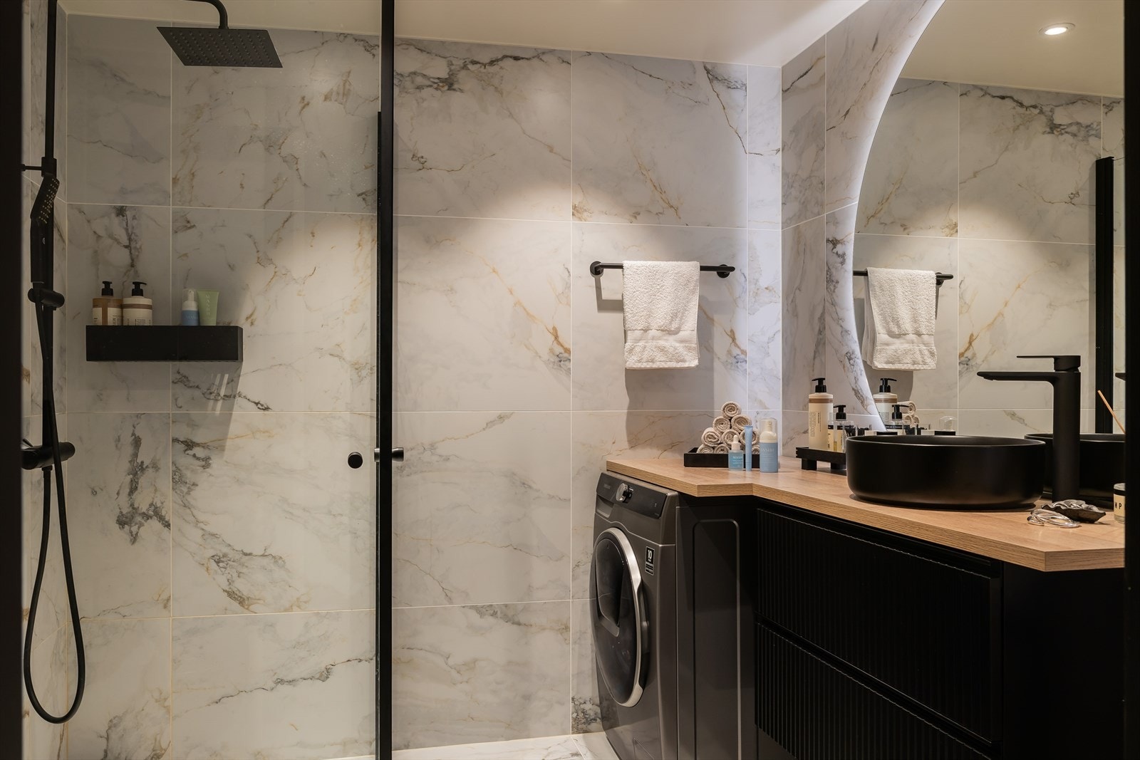Boligens andre baderom holder en høy standard med Modena fliser samt baderomsmøbler fra Nygaard bad. De mørke detaljene står i kontrast til de lyse marmorflisene. Galleribilde