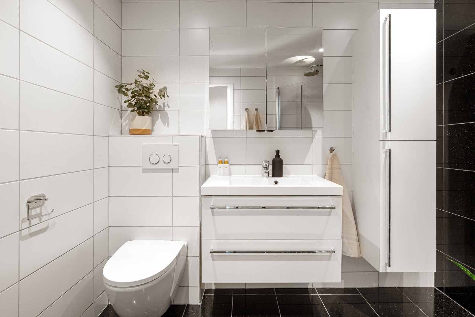 Flislagt gulv med gulvvarme. Innredning med underskap og veggmontert høyskap for god oppbevaring av baderomsartikler. Galleribilde