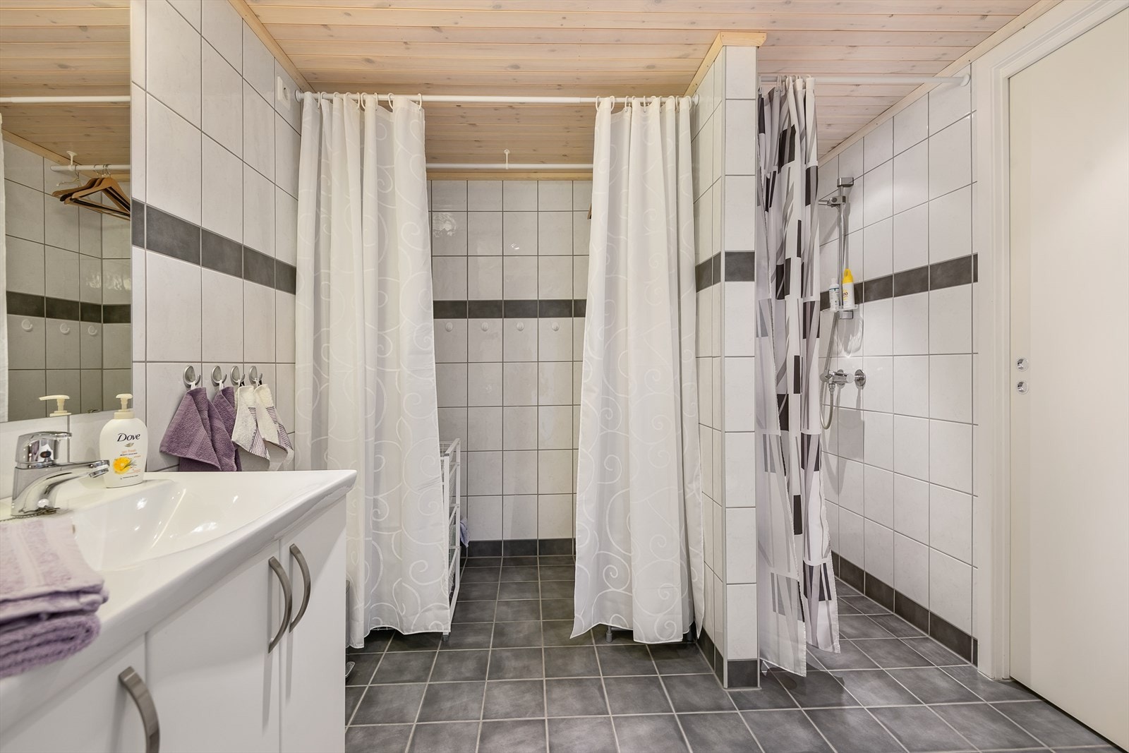Tidløst, flislagt bad med dusj, servantinnredning og wc. Galleribilde