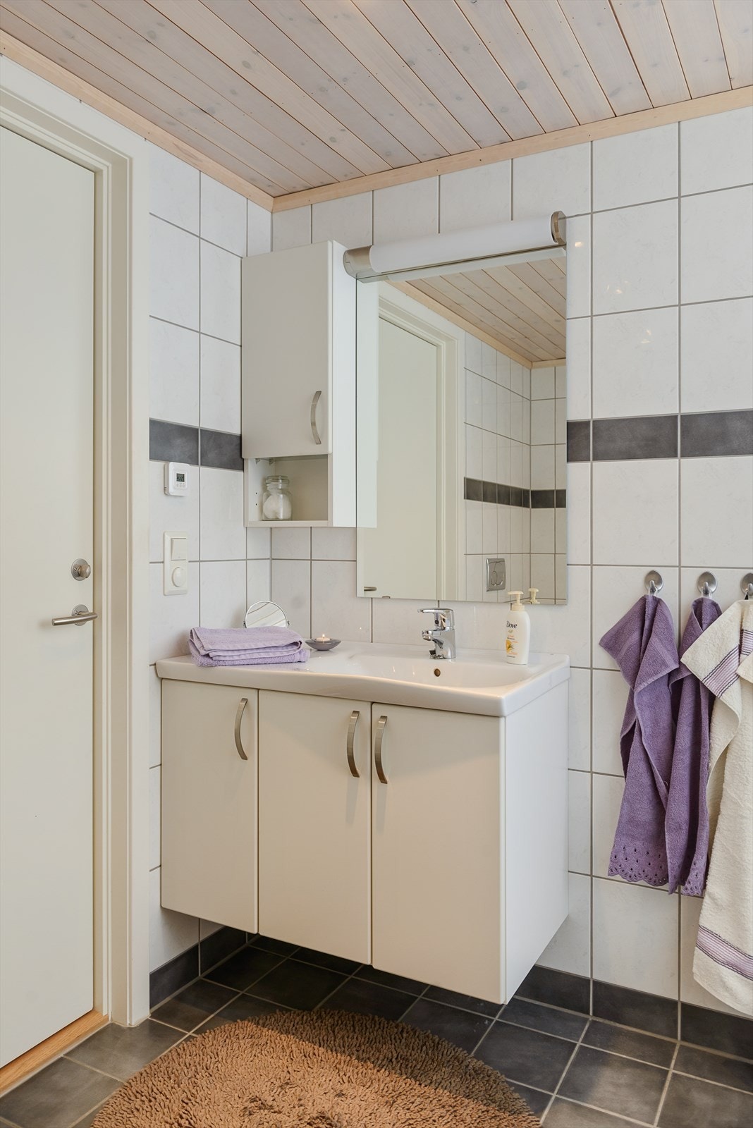 Servantinnredningen har skap for oppbevaring. Glatte, hvite fronter i laminat. Galleribilde