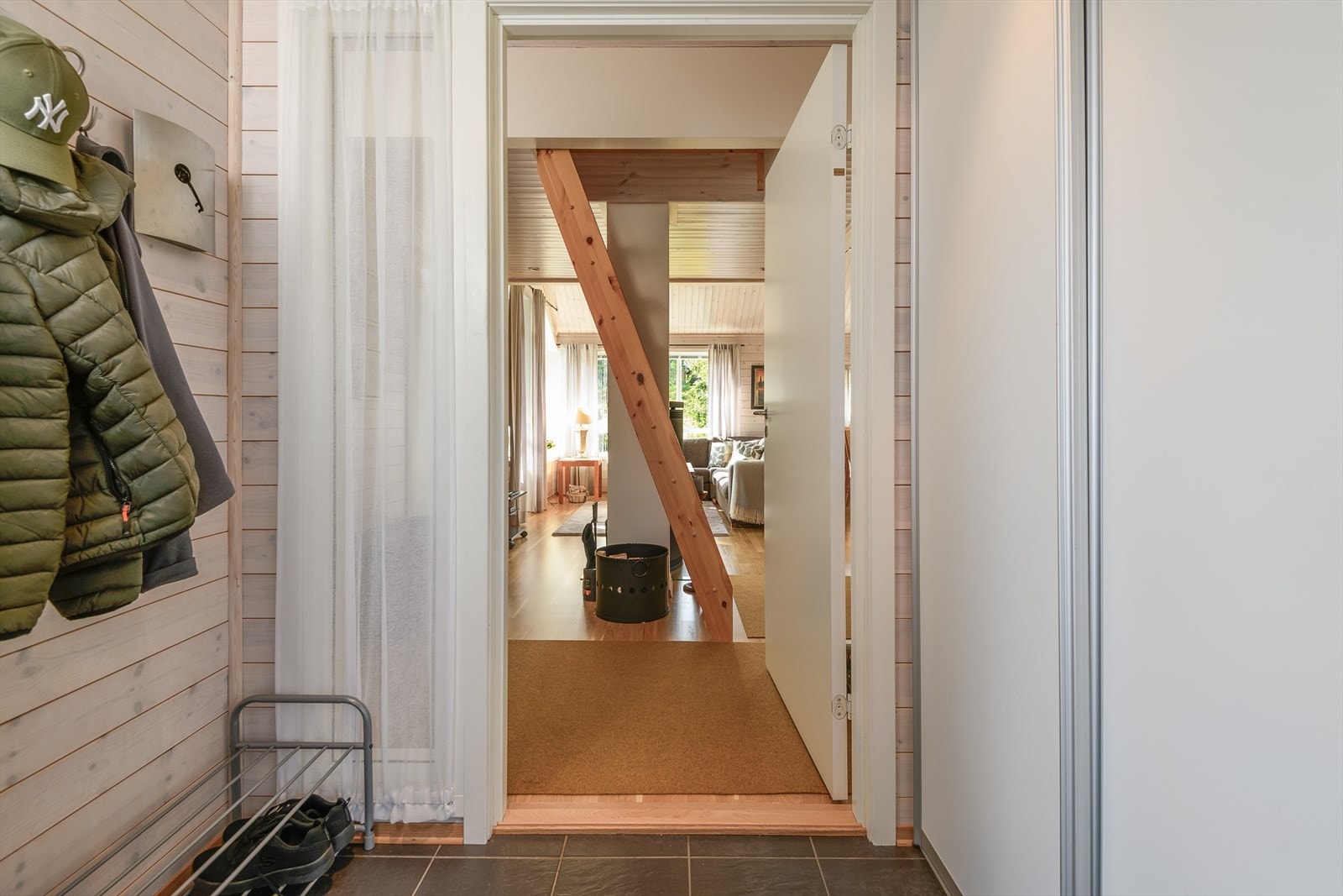 Flislagt gang med plass til å henge fra seg yttertøyet. Skyvedørsgarderobe for smart oppbevaring. Galleribilde