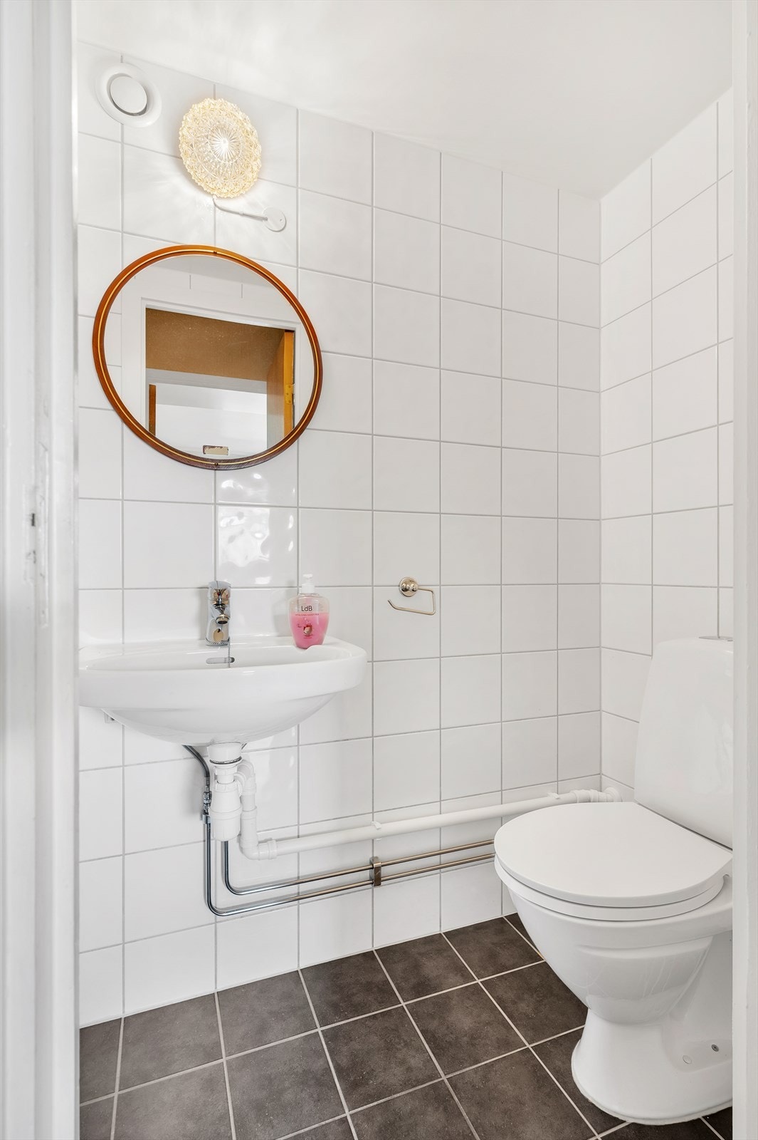 Separat WC som inneholder enkel servant, WC og speil på vegg. Varmekabel? Galleribilde