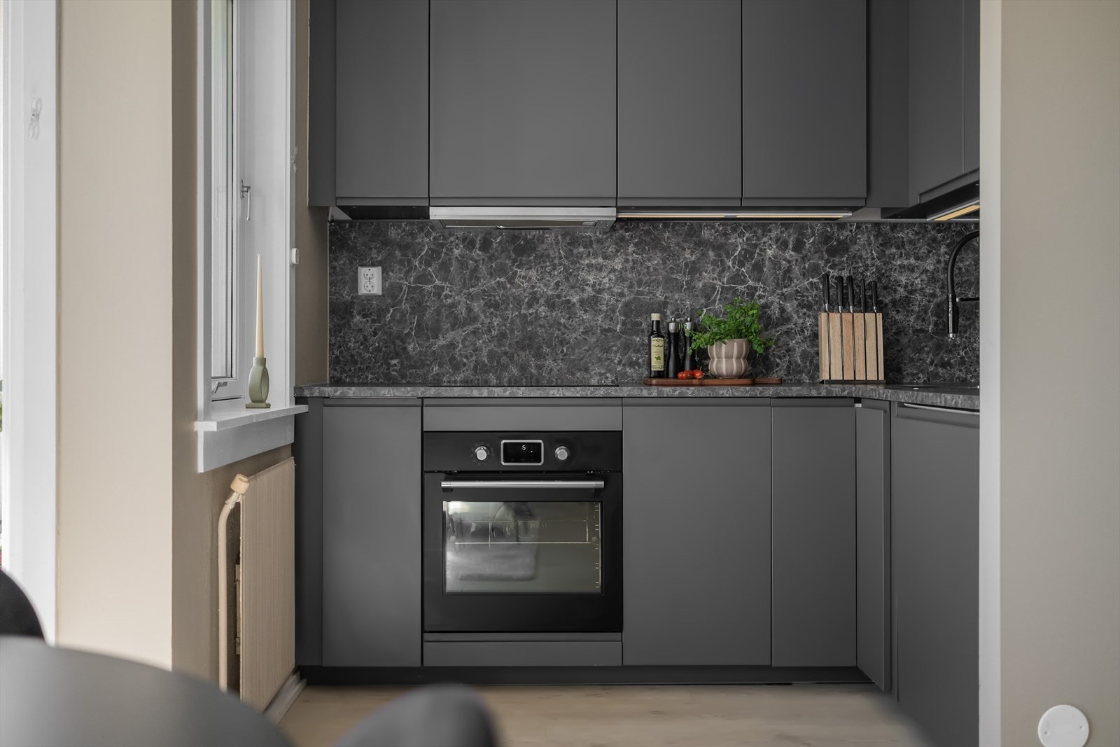 Kjøkkeninnredning fra 2020 med laminerte benkeplater, plateslått backsplash og slette skapfronter. Det er ventilator med kullfilter, samt et felles mekanisk avtrekk er plassert i overkant av overskapene. Galleribilde