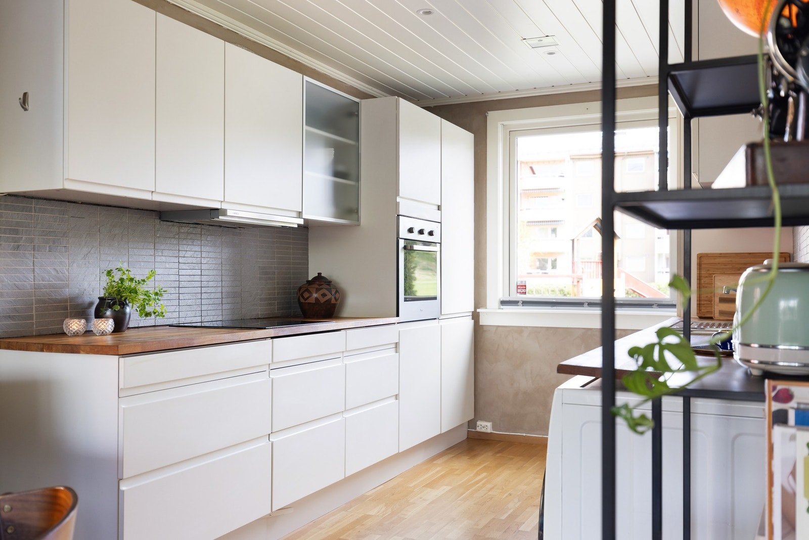 Kjøkkeninnredningen består av fabrikklakkerte glatte fronter og heltre benkeplate med nedfelt oppvaskkum og nedfelt koketopp. Galleribilde