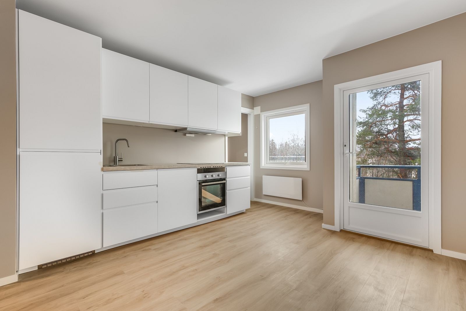 Moderne kjøkken med integrerte hvitevarer som komfyr, platetopp og kombiskap Galleribilde