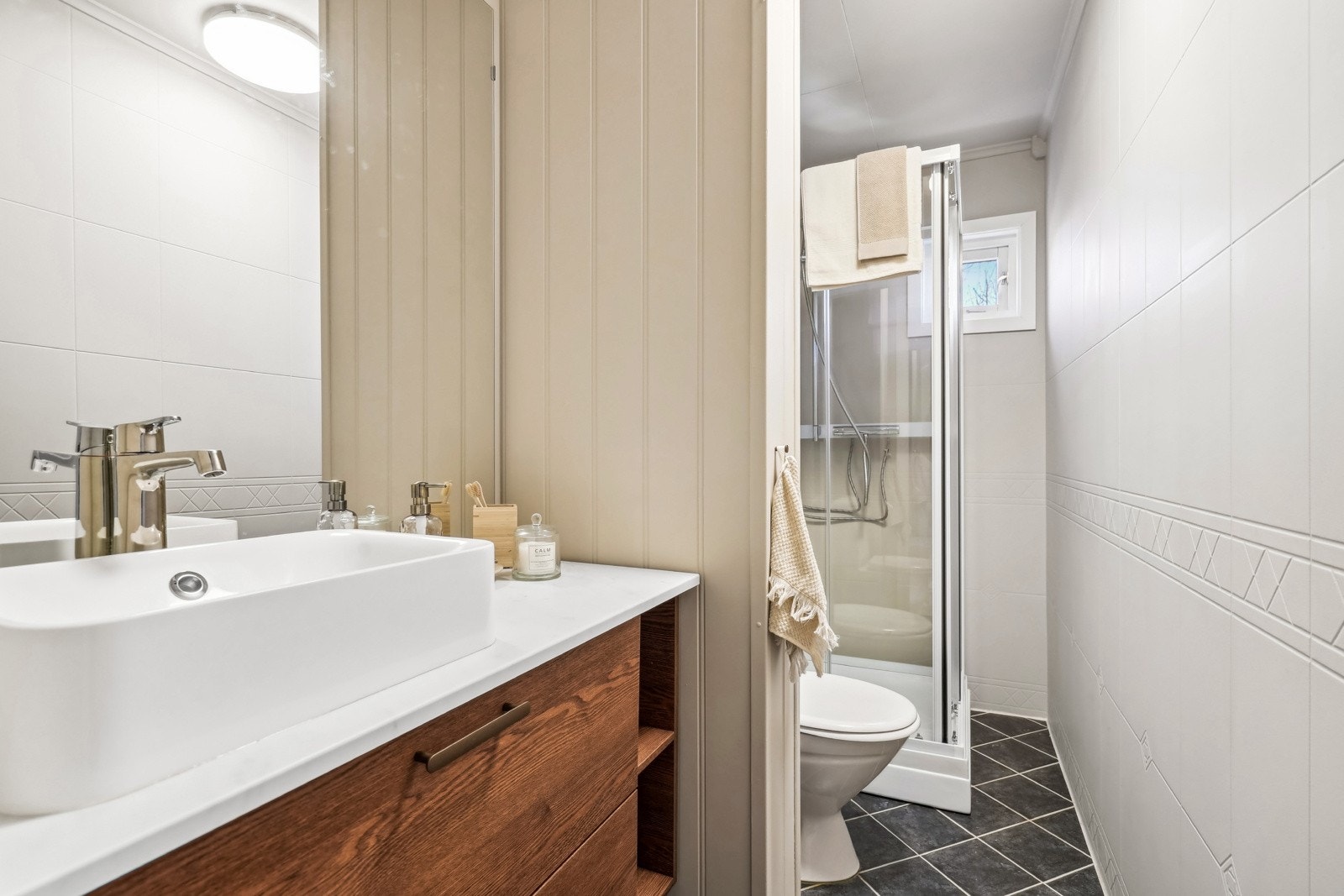 Badet har flislagte gulvflater og malte våtromsplater på veggene. Her får man alt man trenger til hektiske morninger eller til en rask dusj etter løpetur på Aksla. Galleribilde