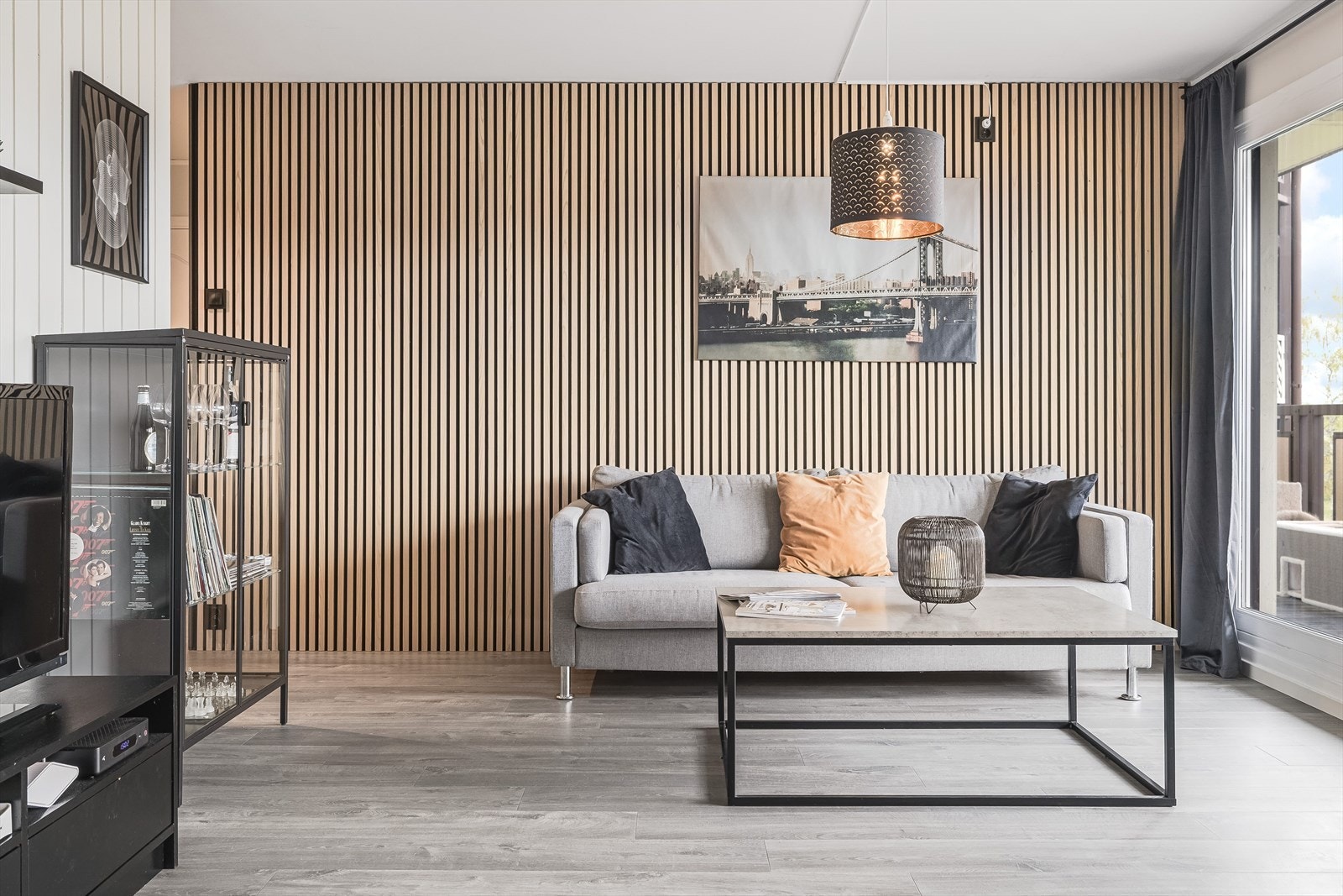 Leiligheten er oppgradert det siste året med nytt gulv i stue, kjøkken og entré, og har en stilig spisevegg bak sofaen. Galleribilde