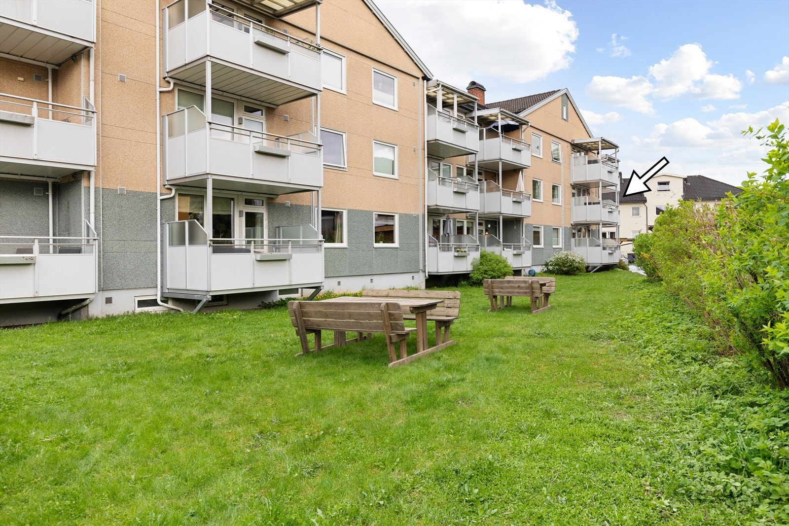 Borettslaget har fine fellesarealer med gressplen og sittebenker Galleribilde