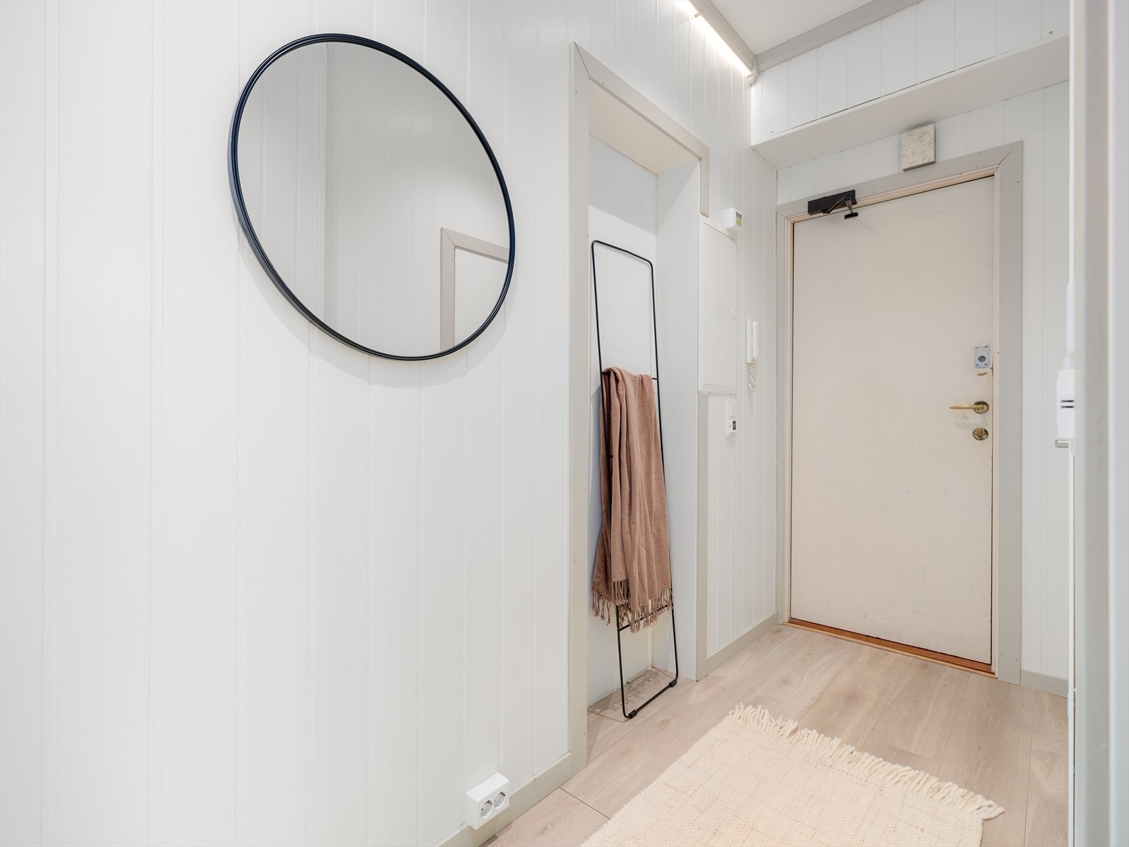 Inngangspartiet gir et godt førsteinntrykk av leiligheten. Her har du plass til å henge fra deg yttertøy og sette fra deg sko. Galleribilde