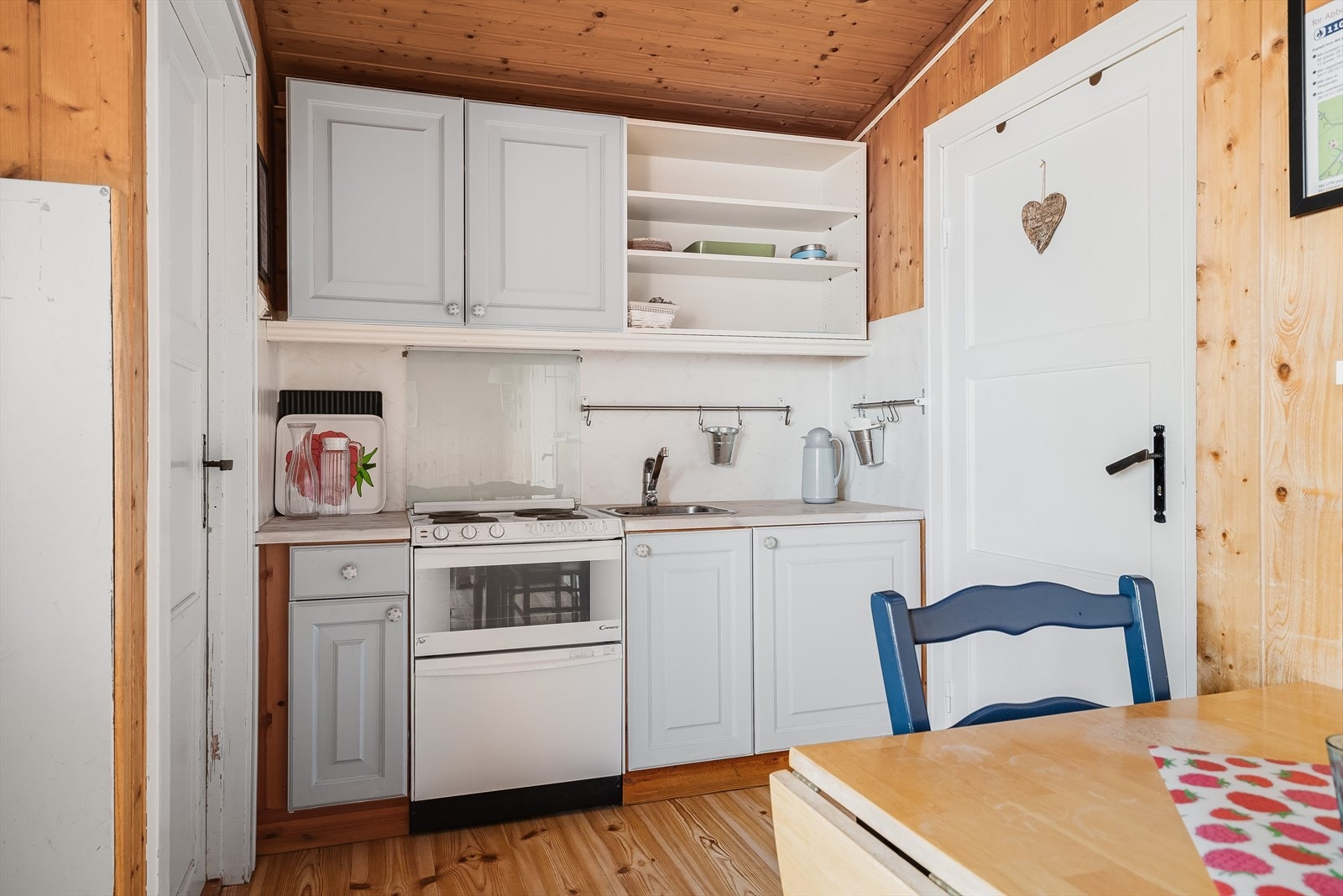 Enkel kjøkkeninnredning med lyse profilerte fronter og laminert benkeplate. Galleribilde