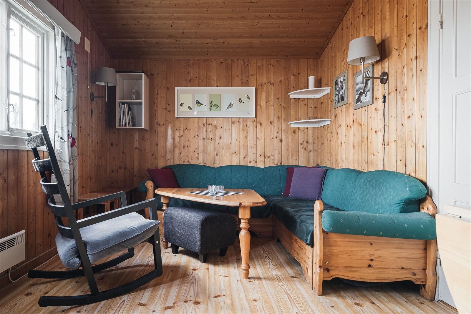 Stue med trepanel på veggene og vindusflater mot syd. Galleribilde