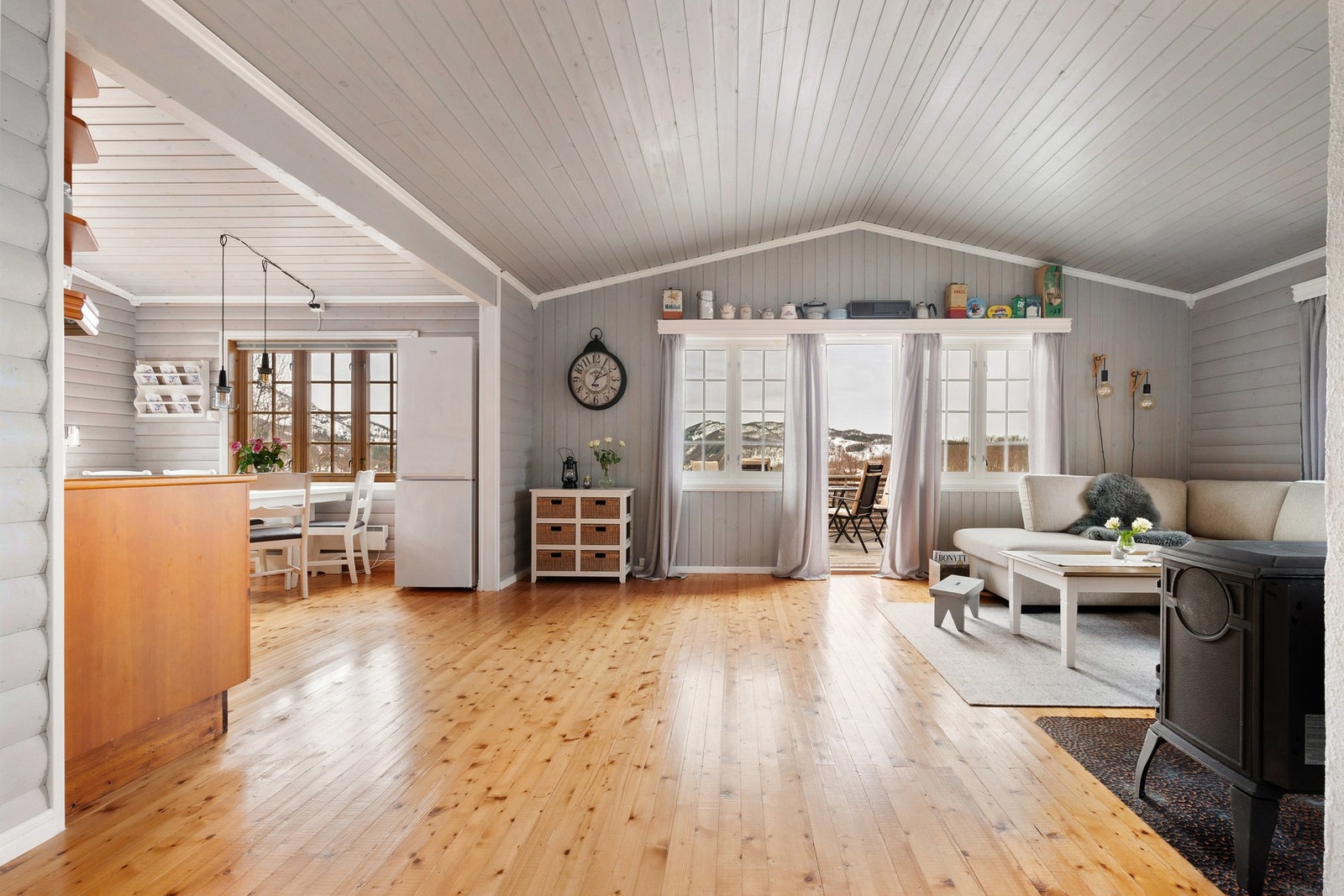 Stue med fin takhøyde og åpent inn mot kjøkkenet Galleribilde