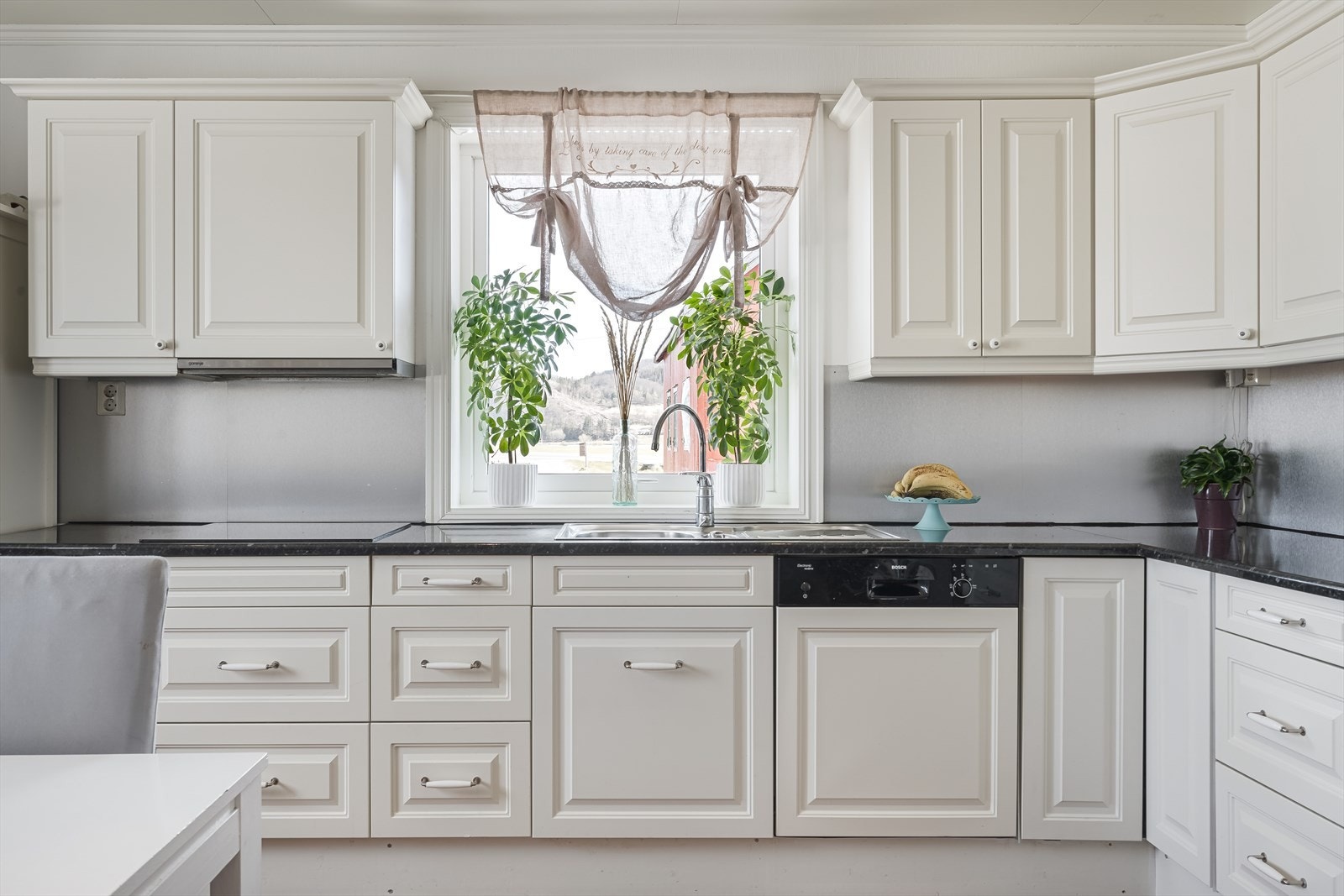 Kjøkkenet har rikelig med plass til et spisebord og har en L-formet innredning med profilerte fronter og laminat benkeplate. Galleribilde