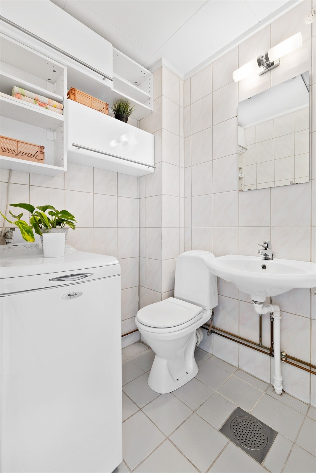 Bad med fliser på vegg og gulv, samt varmekabler. På badet er det opplegg til vaskemaskin. Galleribilde