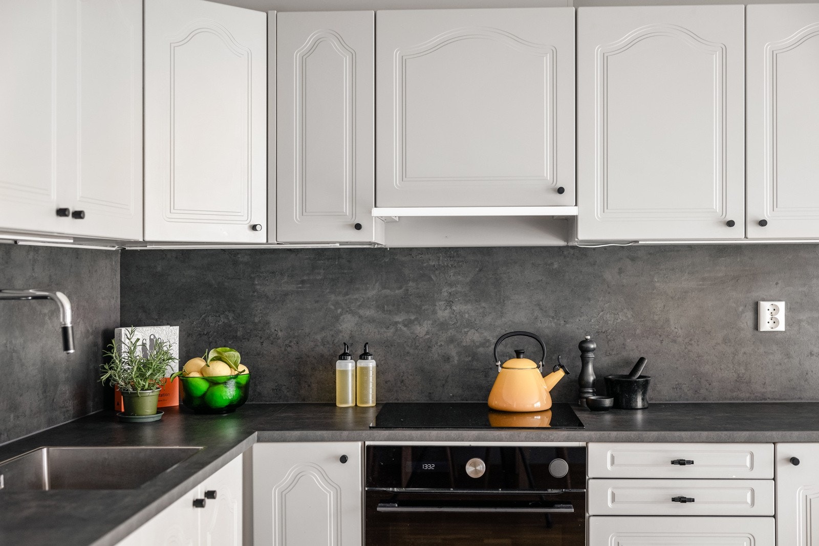 Innredningen har lyse profilerte fronter, laminert benkeplate med planlimt oppvaskkum og armatur med uttrekkbar tut. Praktisk med plater i benkeryggen og belysning under overskapene. Galleribilde