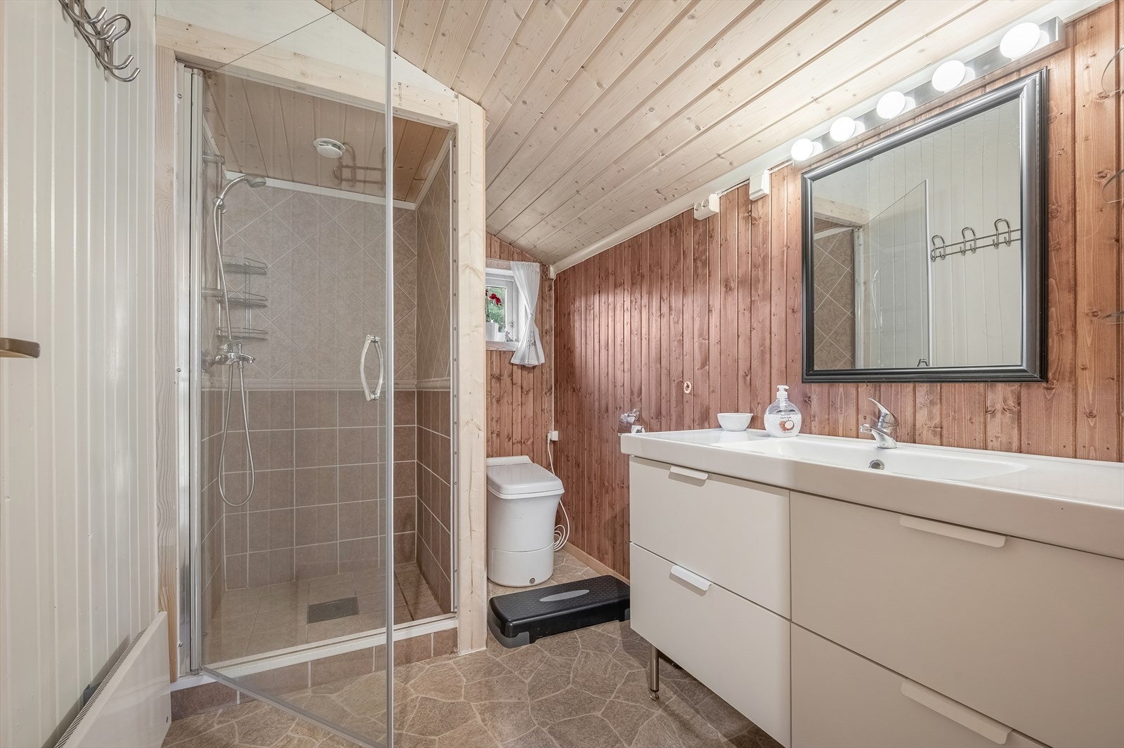 Badet er innredet med dusjnisje, el-forbrenningstoalett og baderomsinnredning med heldekkende servant. Galleribilde