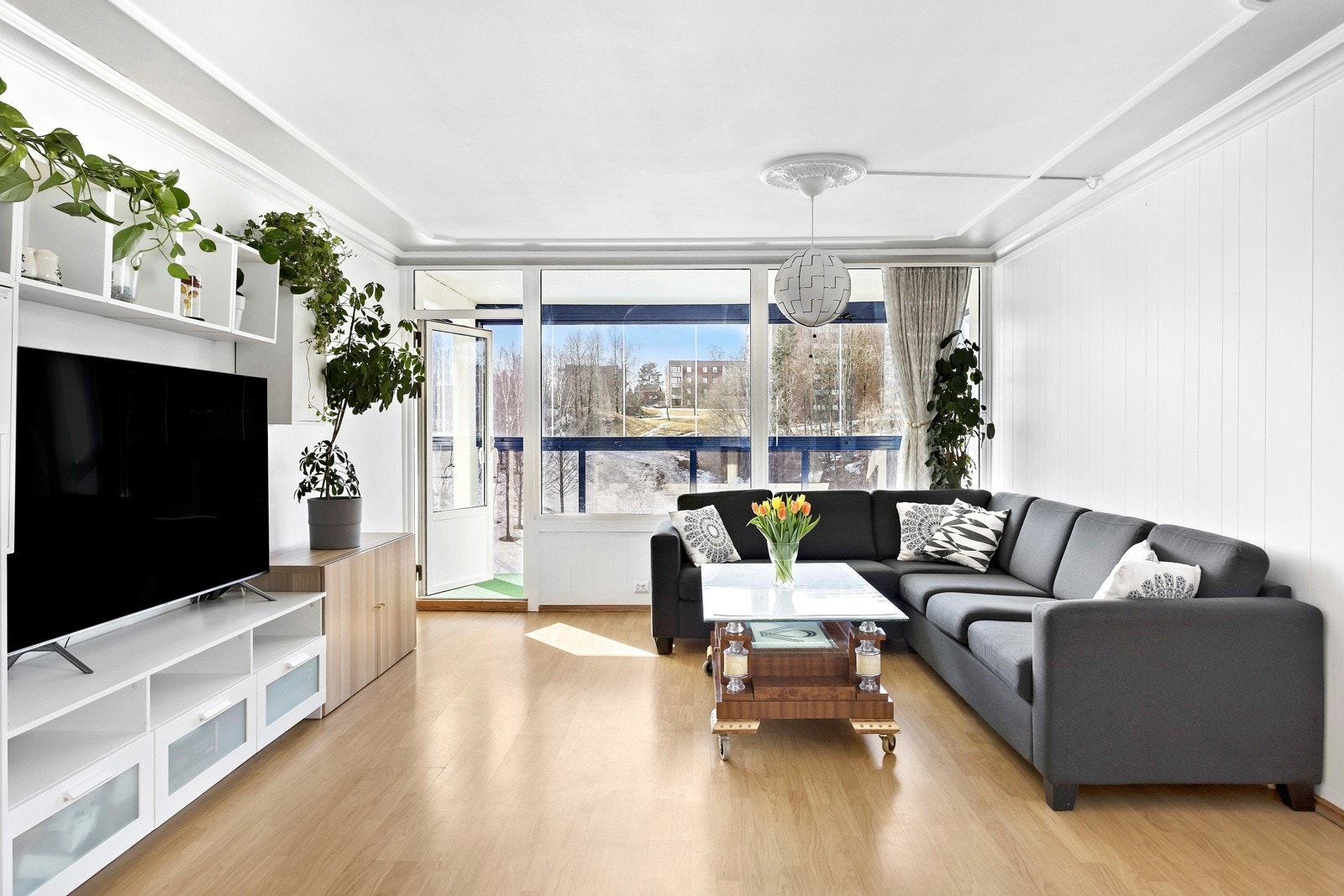 Store vindusflater sørger for gode lys- og solforhold inn i leiligheten, og en luftig atmosfære Galleribilde