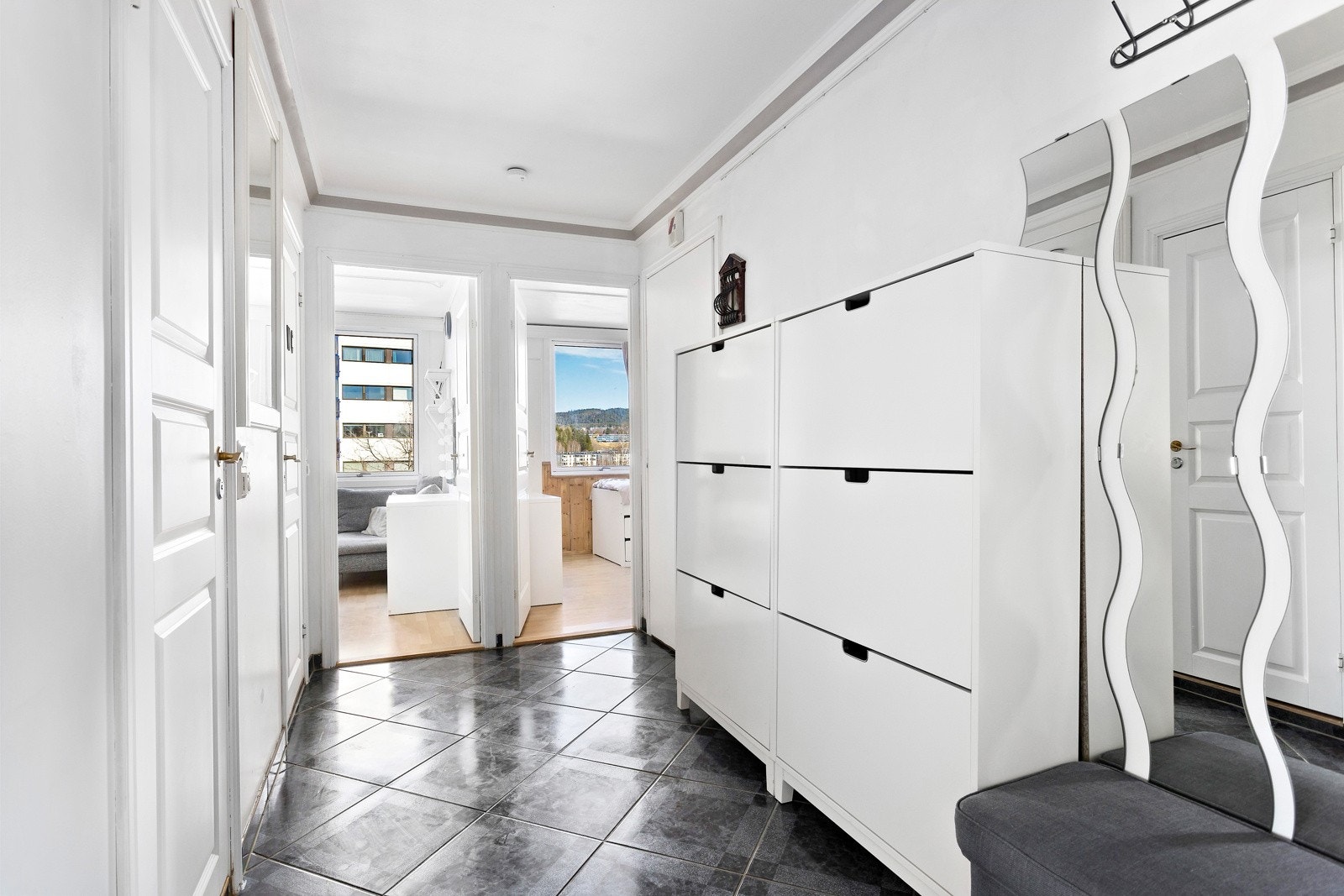 Når du kommer inn i boligen blir du møtt av en hyggelig entre med god plass til oppbevaringsmøbler Galleribilde