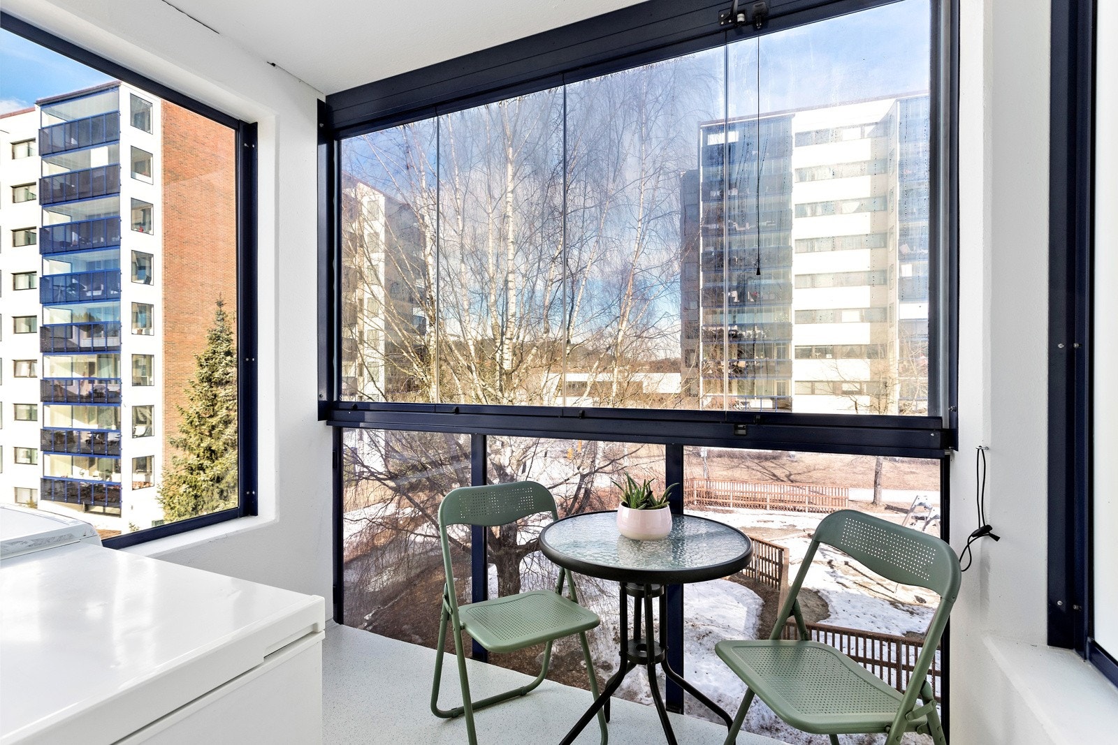 Fra kjøkkenet kommer du ut til en hyggelig nordøstvendt innglasset luftebalkong med morgensol - Her er det plass til å sette ut sittegruppe hvor morgensolen kan nytes med frokost og kaffen. Galleribilde