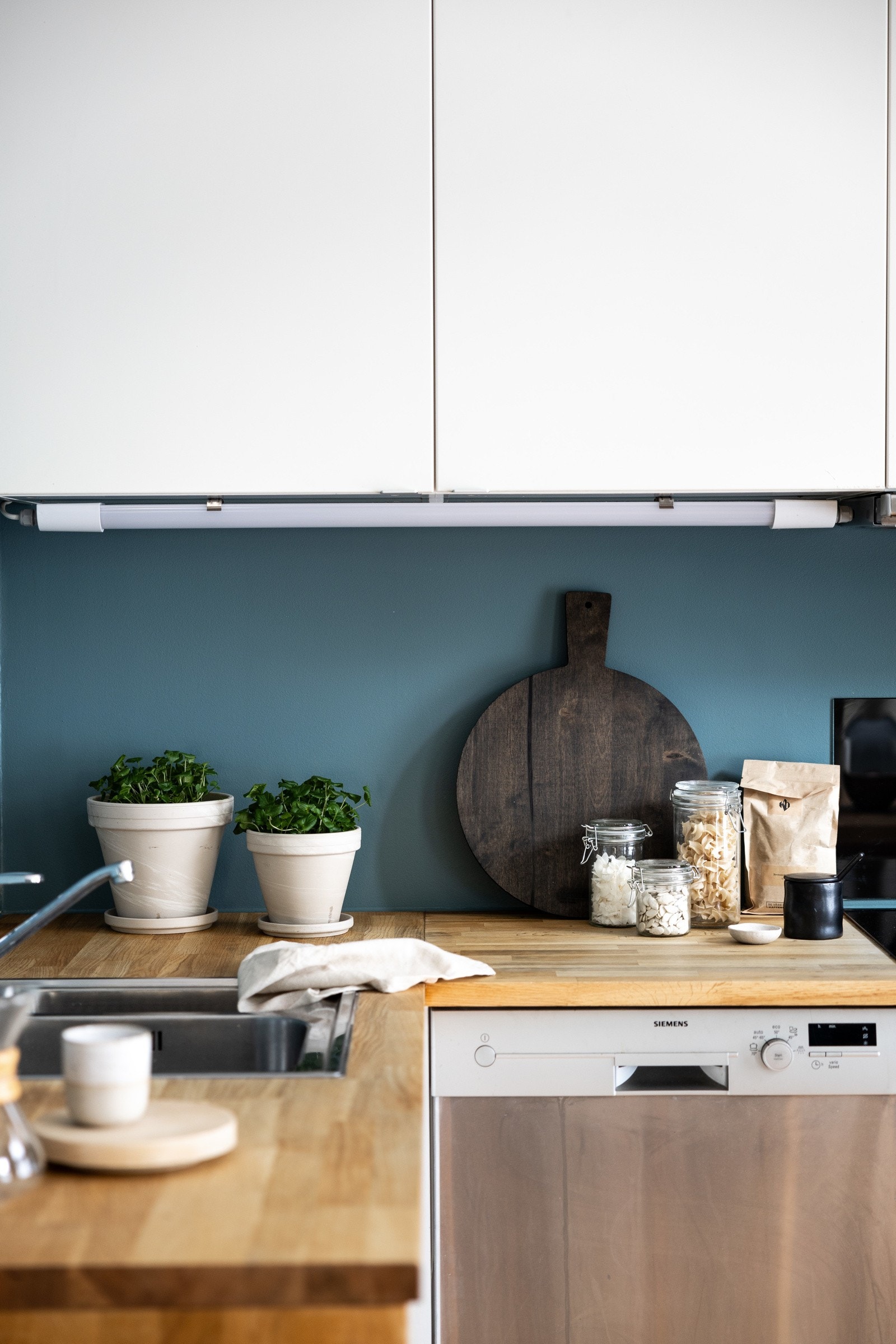 Det er overskapsbelysning og stikkontakter på vegg over benkeplate. Galleribilde