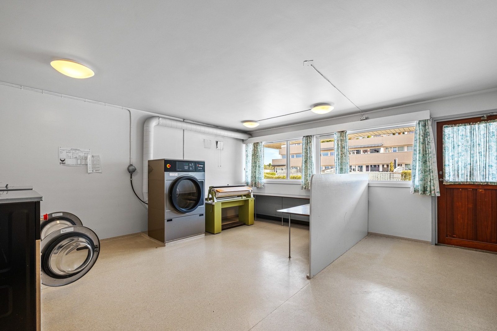 Felles vaskeri i 1. etasje med industrimaskiner, tørkerom og tørketrommel. Galleribilde