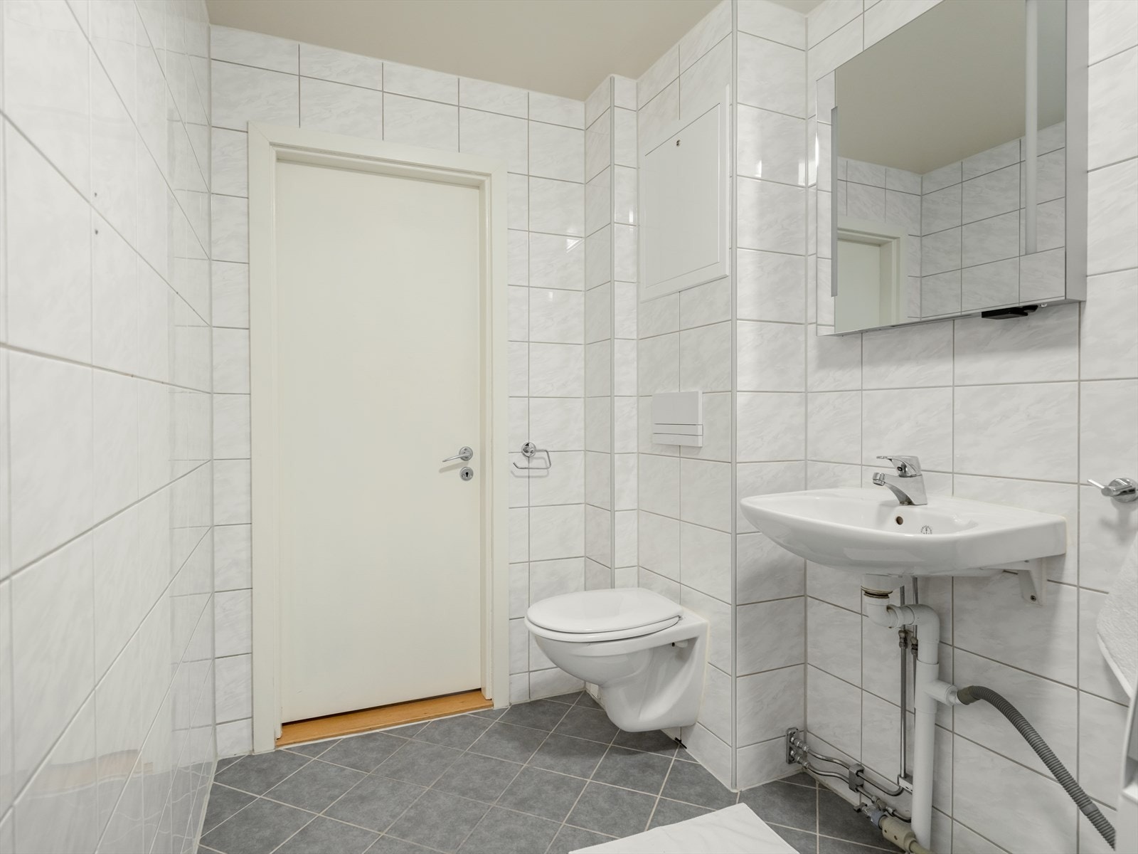Badet er utstyrt med servant, speilm/integrert lys, veggmontert toalett og dusjkabinett. Det er opplegg for vaskemaskin og naturlig ventilering. Galleribilde