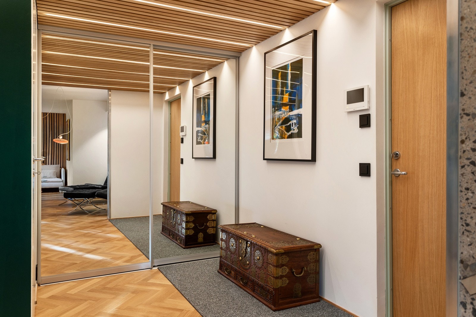 Entreen er delikat og gir et solid og godt førsteinntrykk av leiligheten. Yttertøy og sko kan ryddes pent bort i en praktisk skyvedørsgarderobe med speilfronter Galleribilde