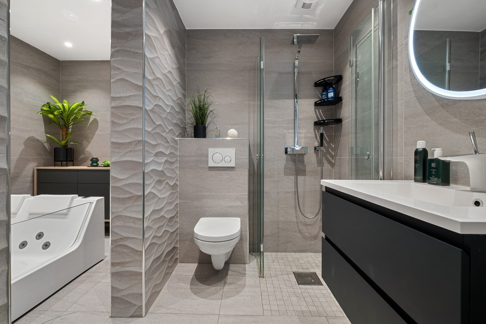 Innredet med vegghengt klosett, servant nedfelt i innredning, dobbelt massasjeboblebad og dusjhjørne med svingbare glassdører. Mekanisk avtrekk. Galleribilde