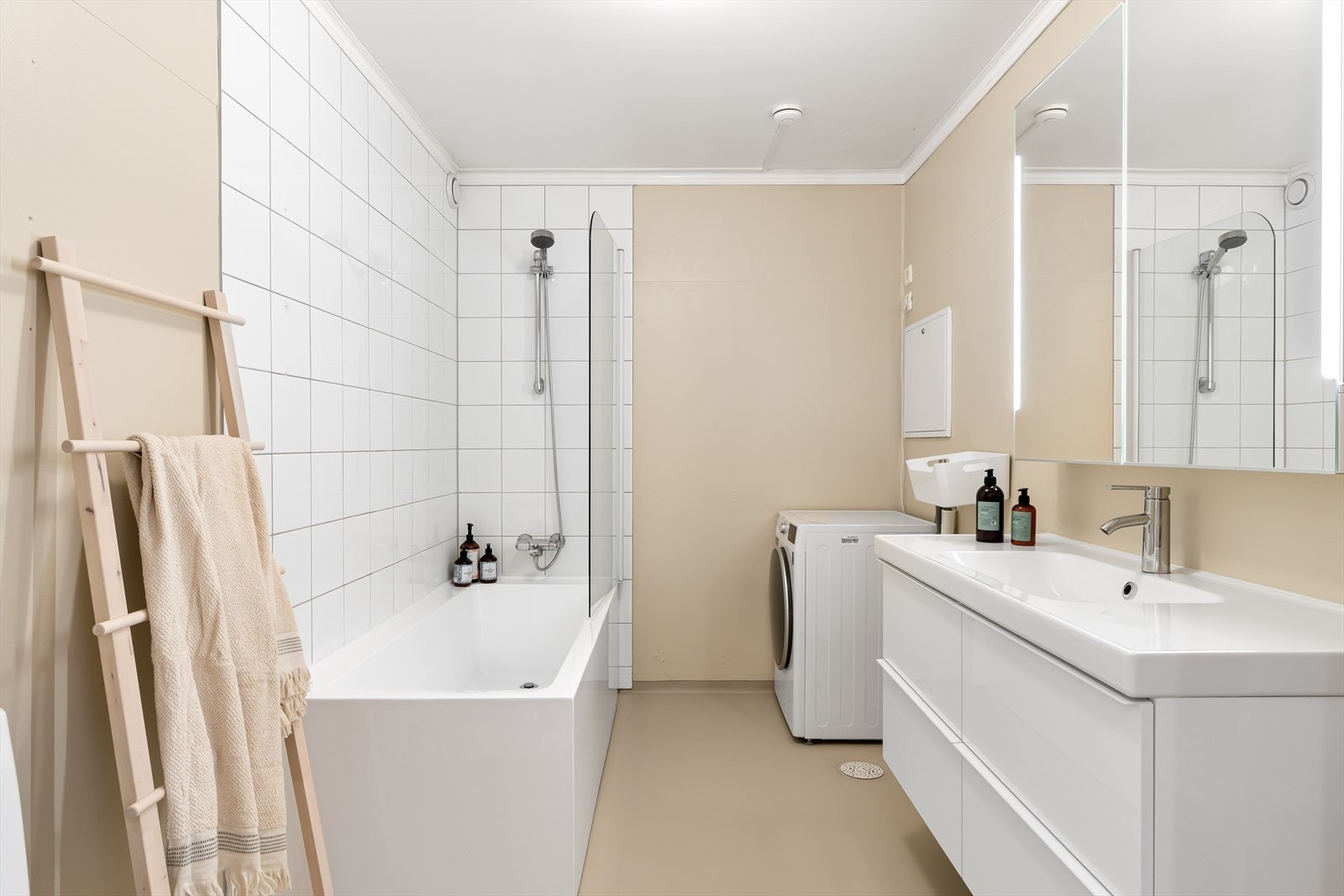 Flott og romslig bad med nedfelt servant, toalett, badekar og opplegg for vaskemaskin/tørketrommel Galleribilde