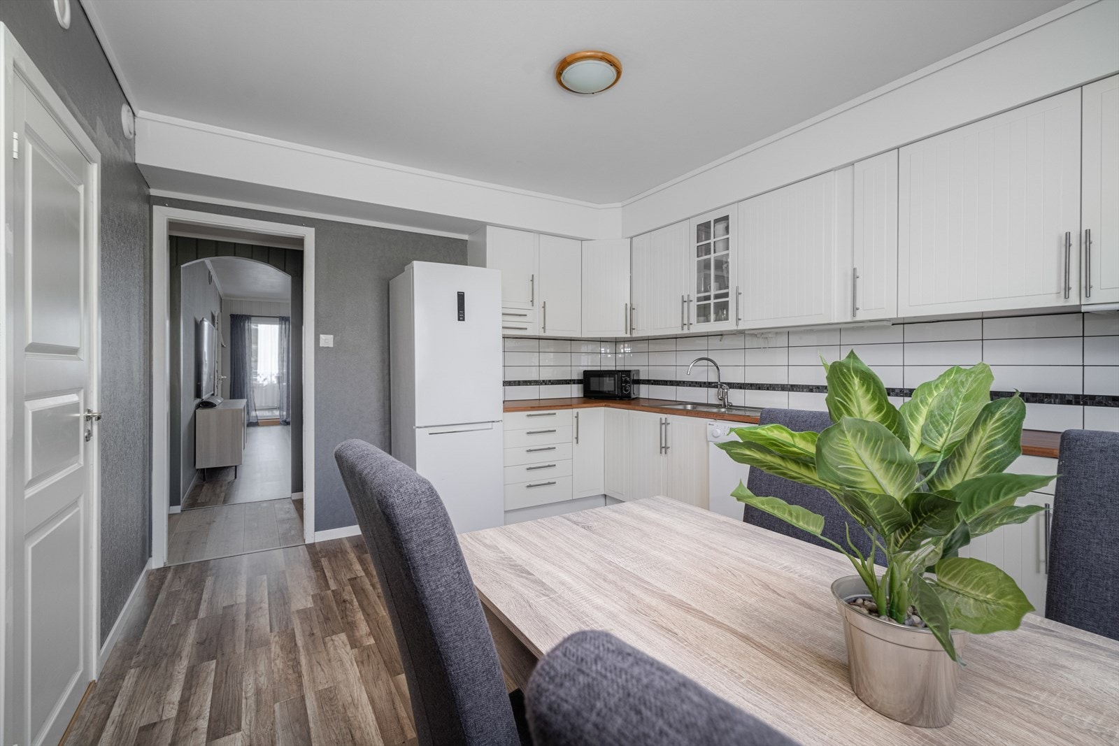 Kjøkkenet har en lys IKEA innredning fra ca. 2010 med profilerte fronter og noe glasskap, laminat benkeplate og flis over kjøkkenbenk. Galleribilde