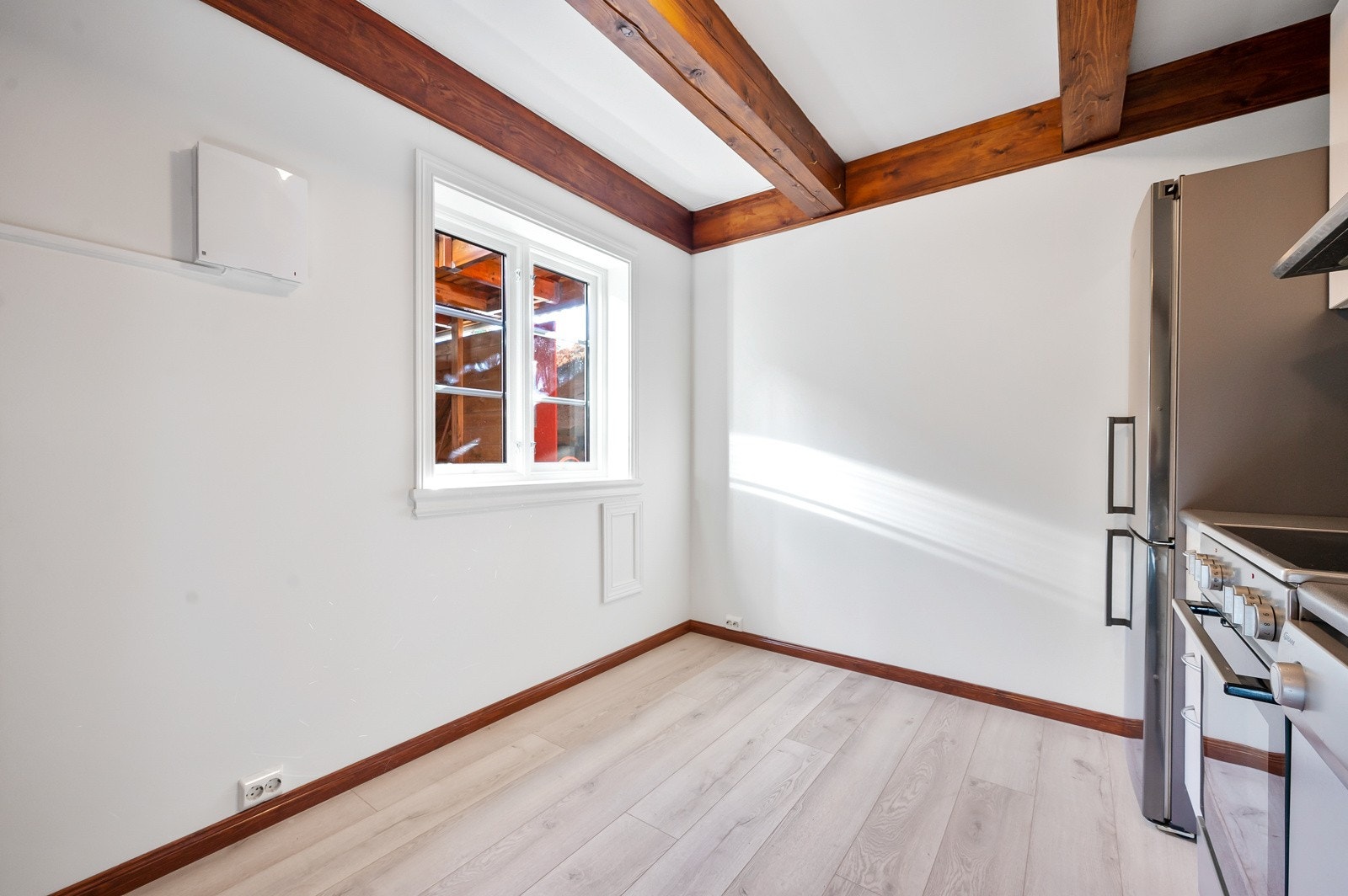 Vinduet på kjøkkenet slipper inn godt med naturlig lys, og det er plass til frokostbord. Galleribilde