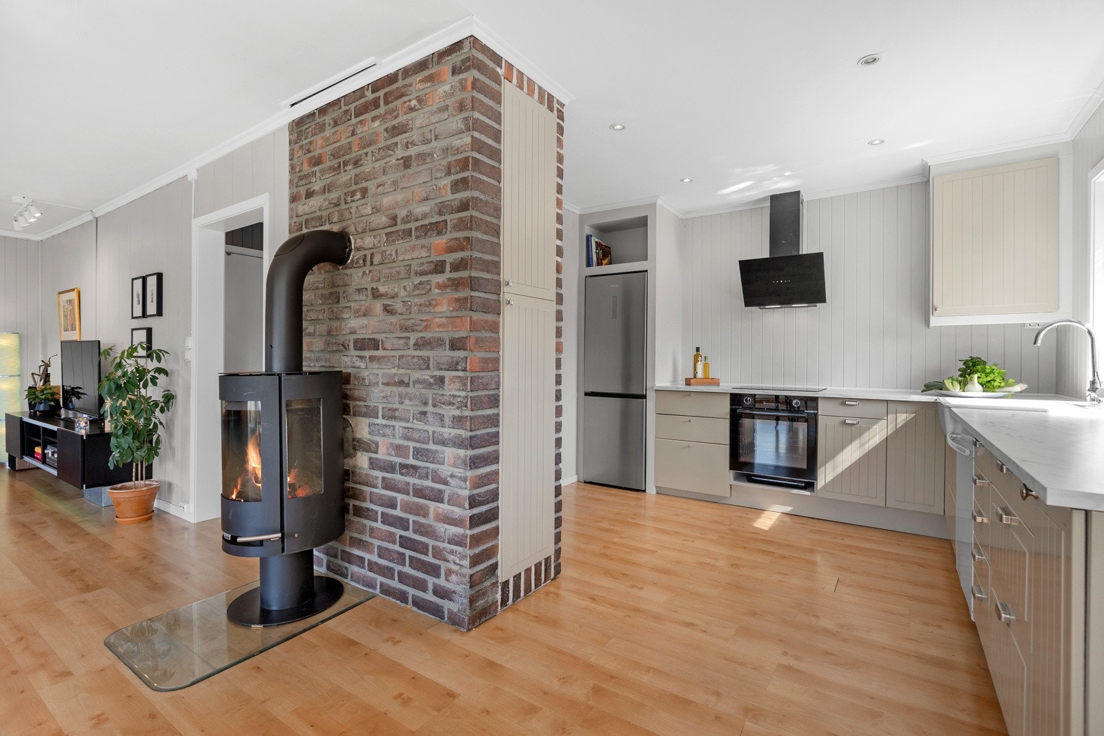 Nyere peisovn som effektiv varmekilde. Åpent inn til kjøkken. Galleribilde