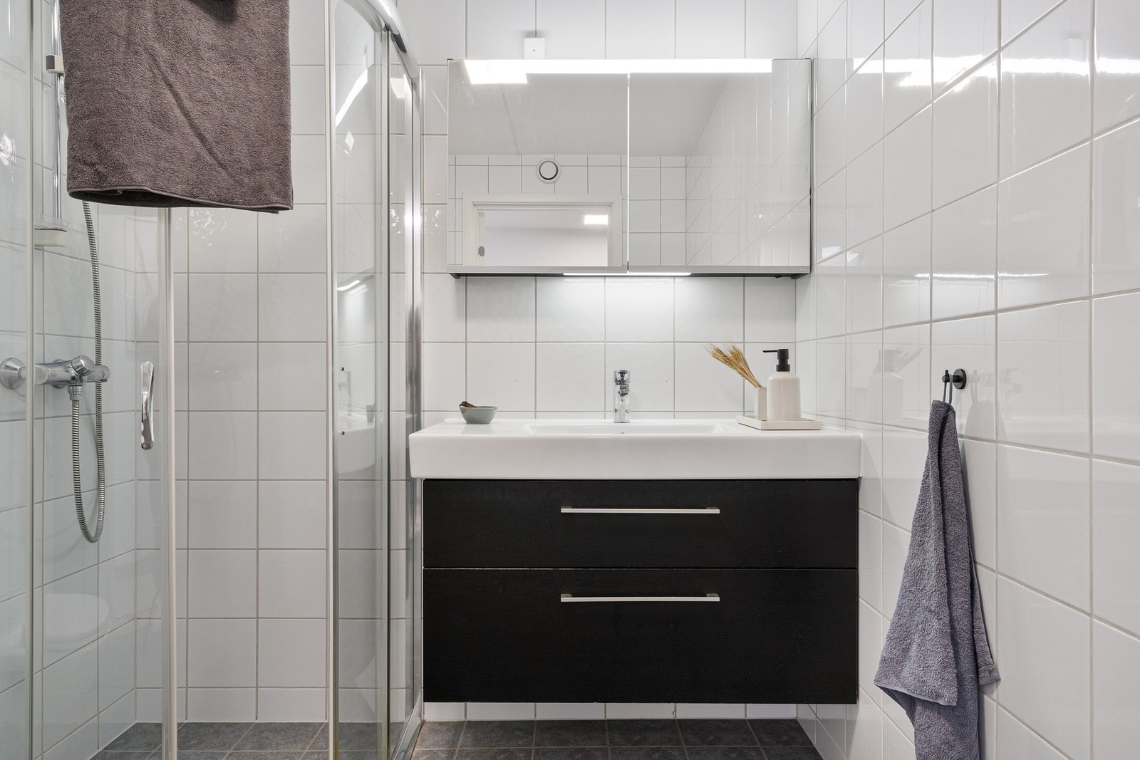 Badet har innredning med servant, vegghengt toalett og dusjhjørne. Galleribilde