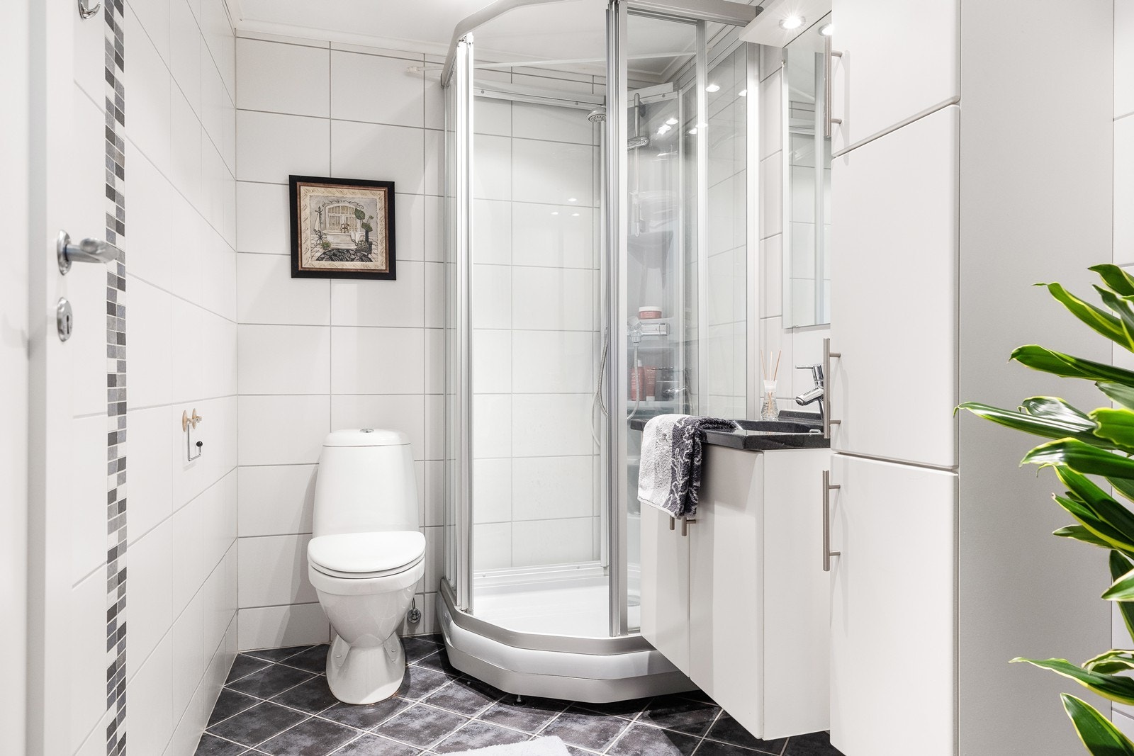 Et klassisk og pent bad med keramiske fliser på gulv og vegg og malt plate i taket. Varme i gulvet. Galleribilde