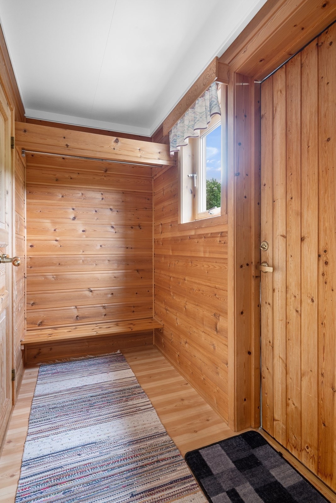 Entreen på fremsiden av hytta har god plass til oppbevaring av yttertøy og sko, her er det også inngang til et tørkerom Galleribilde