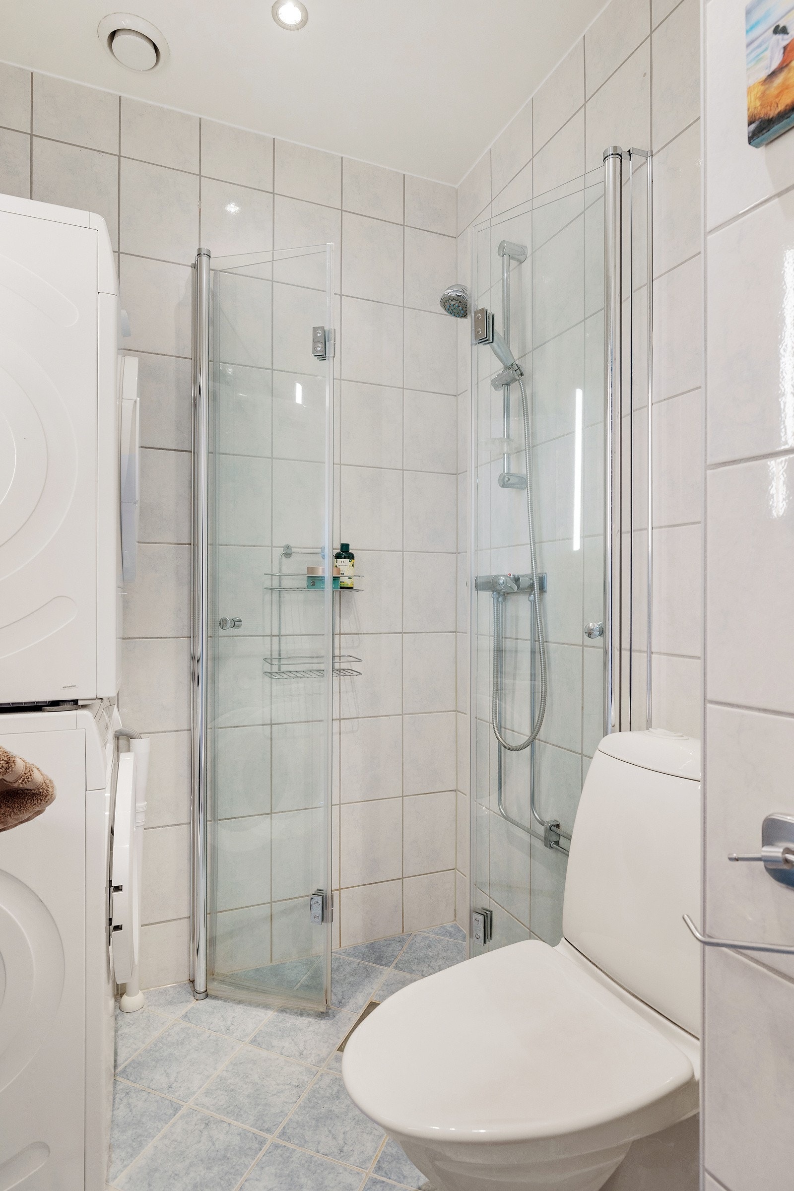 Baderommet har fliser på gulv med gulvvarme, lyse fliser på veggene og downlights i himlingen.Baderommet er også utstyrt med dusjhjørne med innfellbare glassdører og gulvstående toalett. Galleribilde